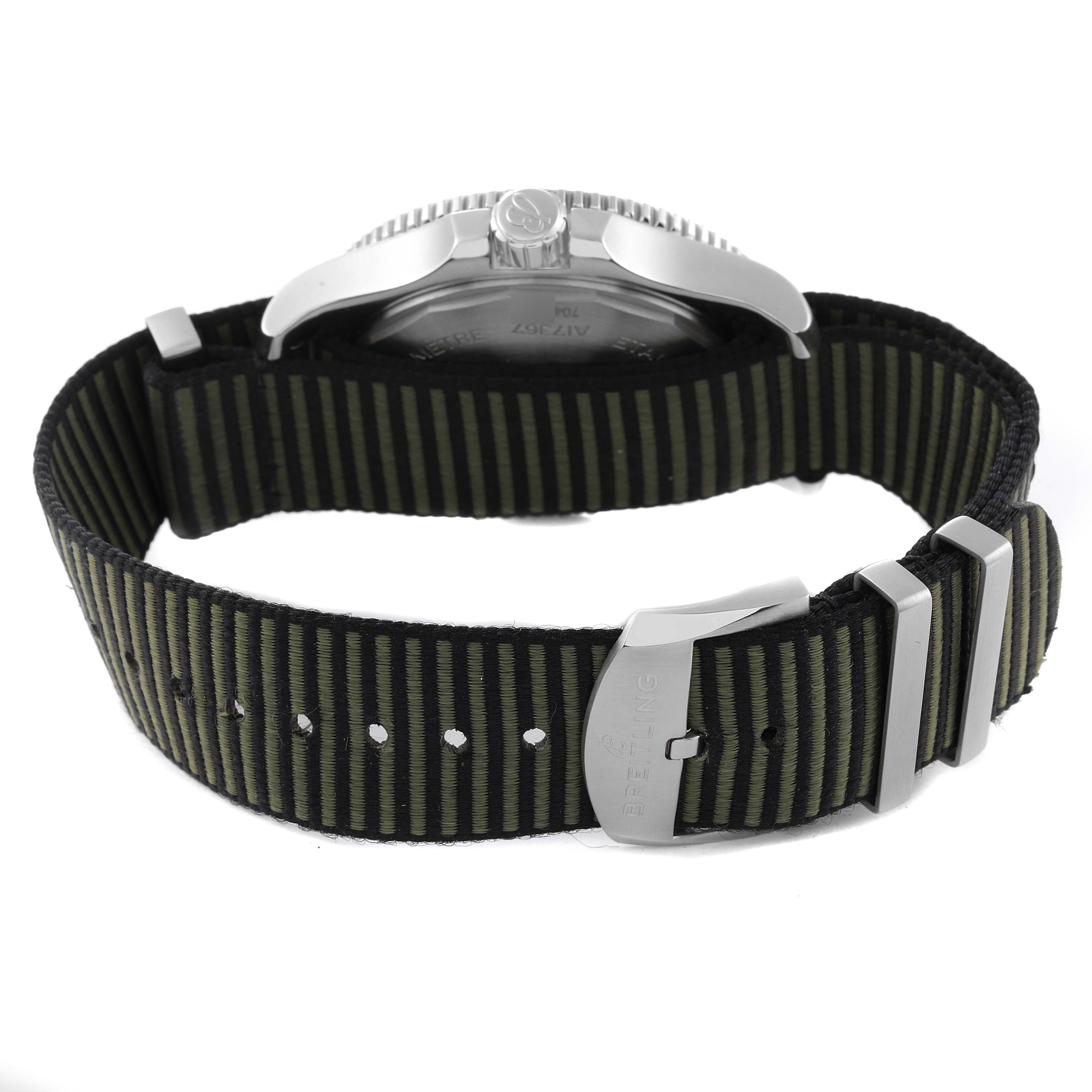 The image shows the back view of a Breitling Superocean A17367A11L1W1 Men's Stainless Steel Green Dial A17367A11L1W1 Men's Stainless Steel Green Dial watch, highlighting the case, crown, and striped fabric strap with a buckle and keepers.