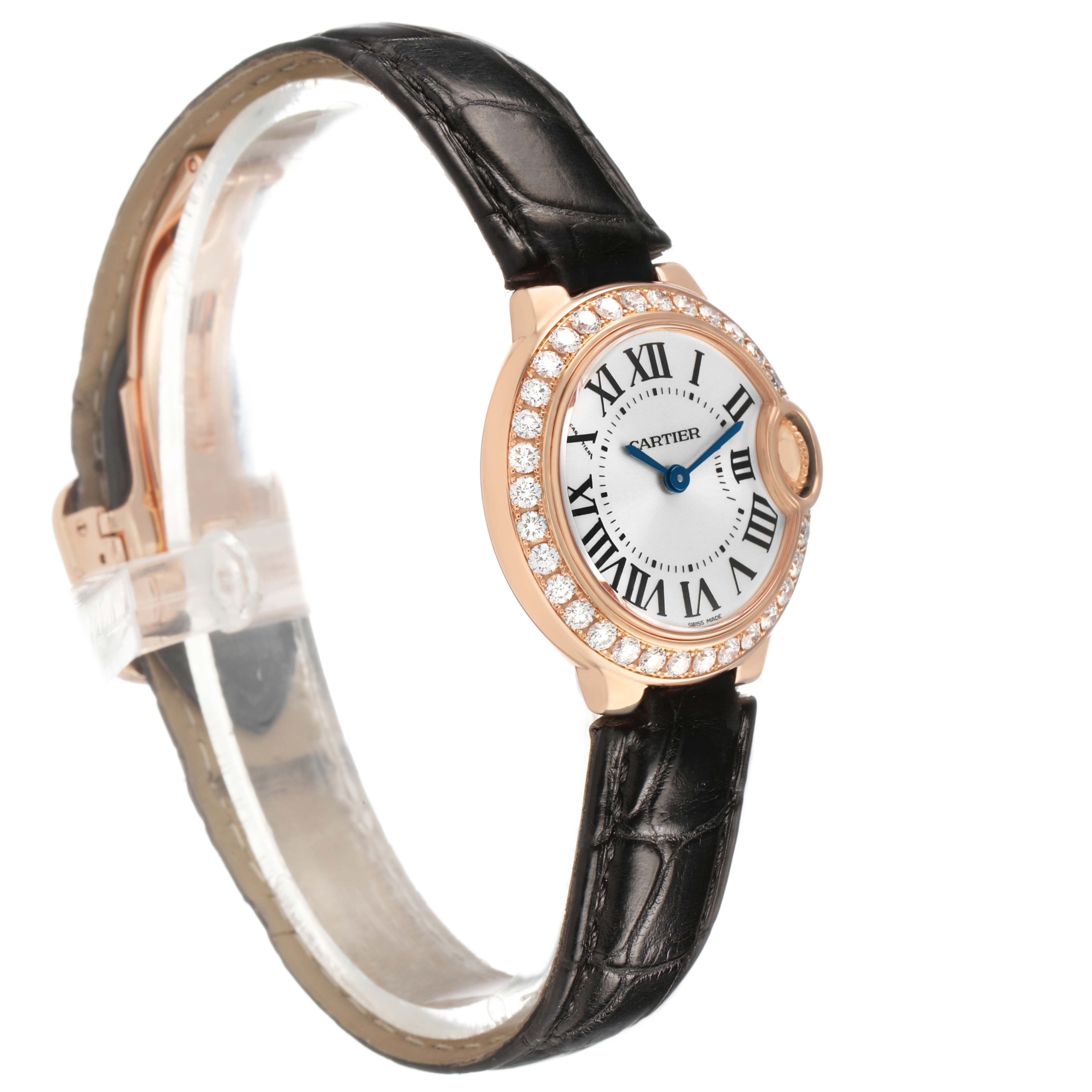 The Cartier Ballon Bleu WE900251 Women's Rose Gold Silver Dial watch is shown at a slight angle, highlighting its diamond-encrusted bezel and leather strap.