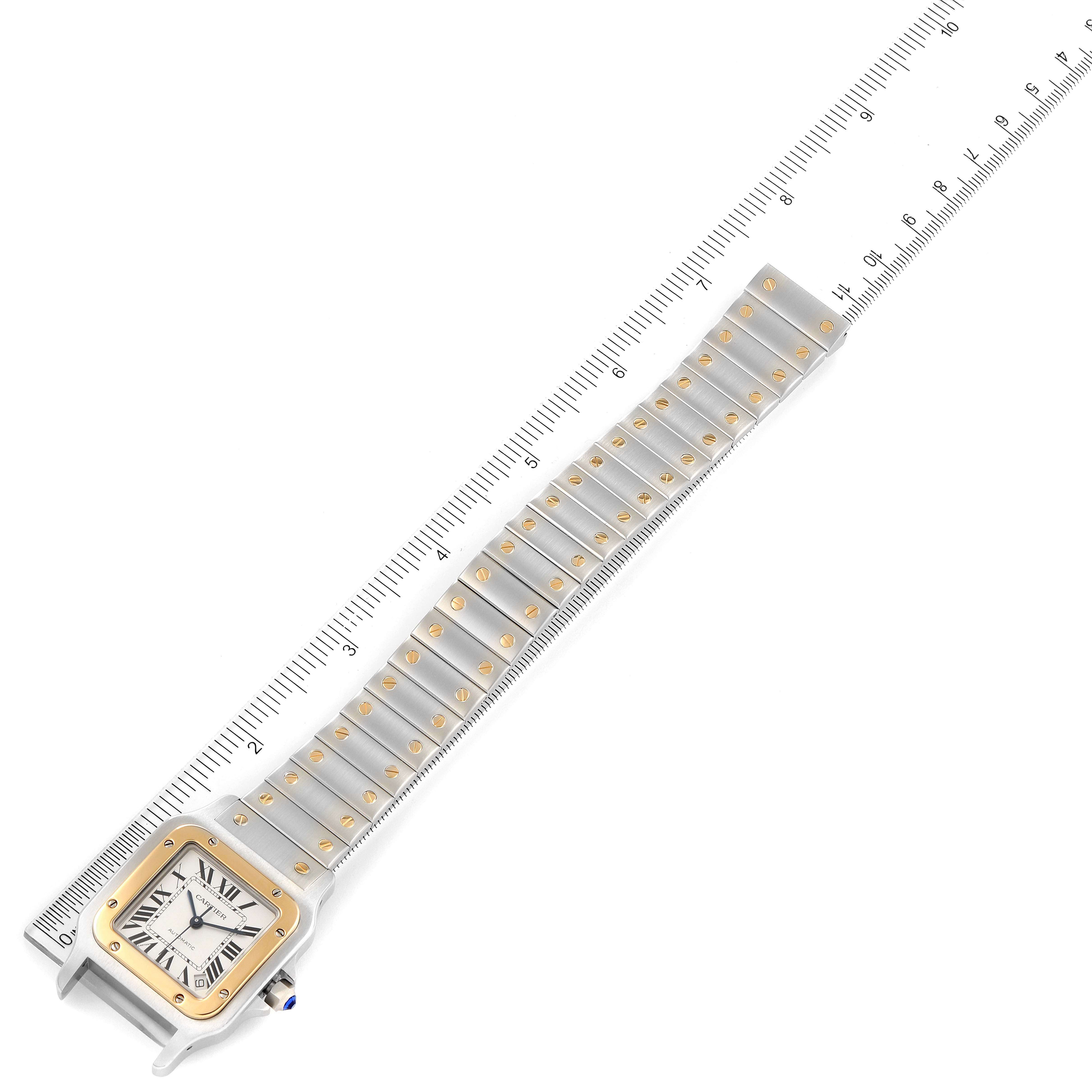 The image shows a Santos de Cartier watch at an angle, including its square face, bezel, and bracelet, measured against a ruler.