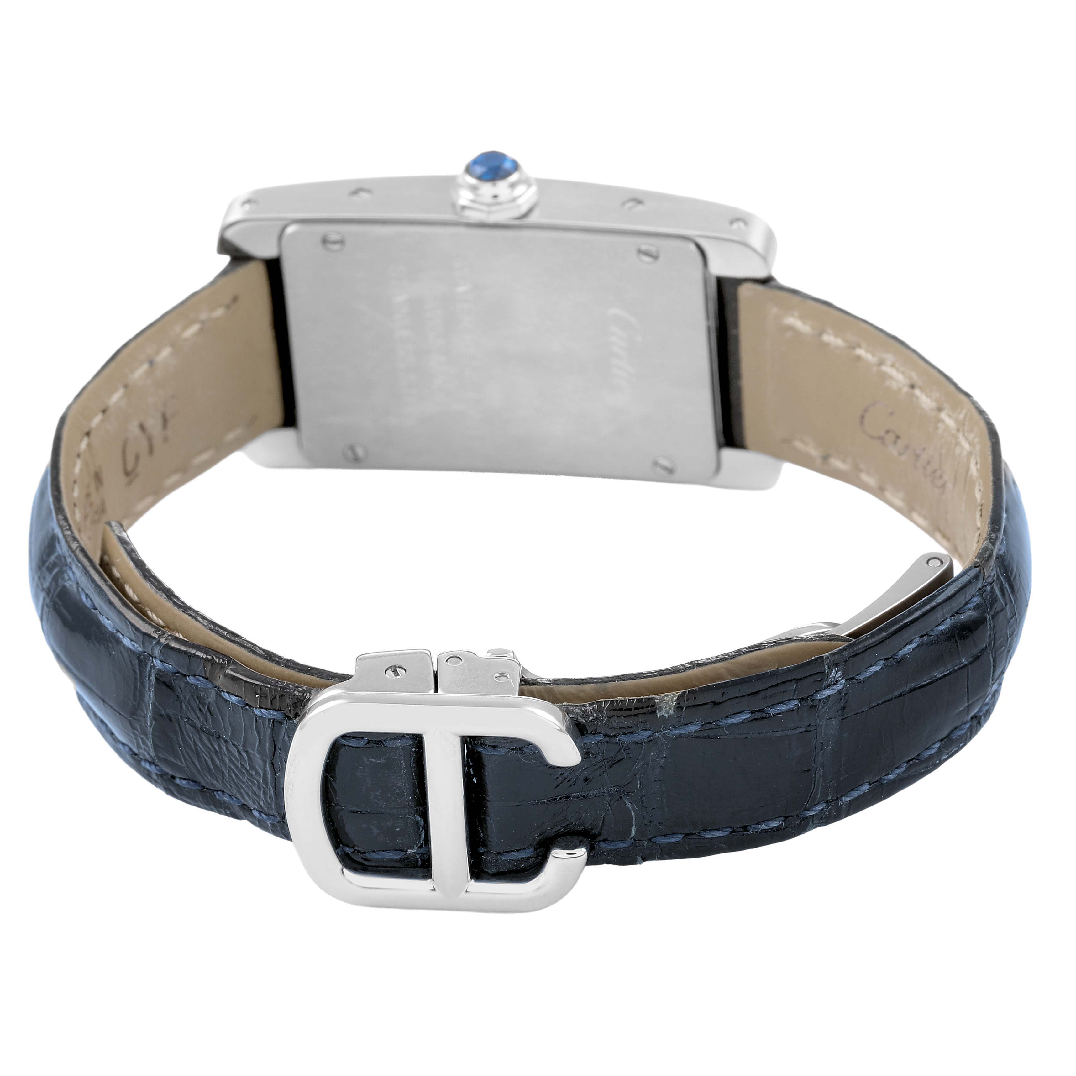 The Cartier Tank Americaine WSTA0016 Women's Stainless Steel Silver Dial watch is shown from the back, highlighting the strap, clasp, case back, and crown with a blue cabochon.