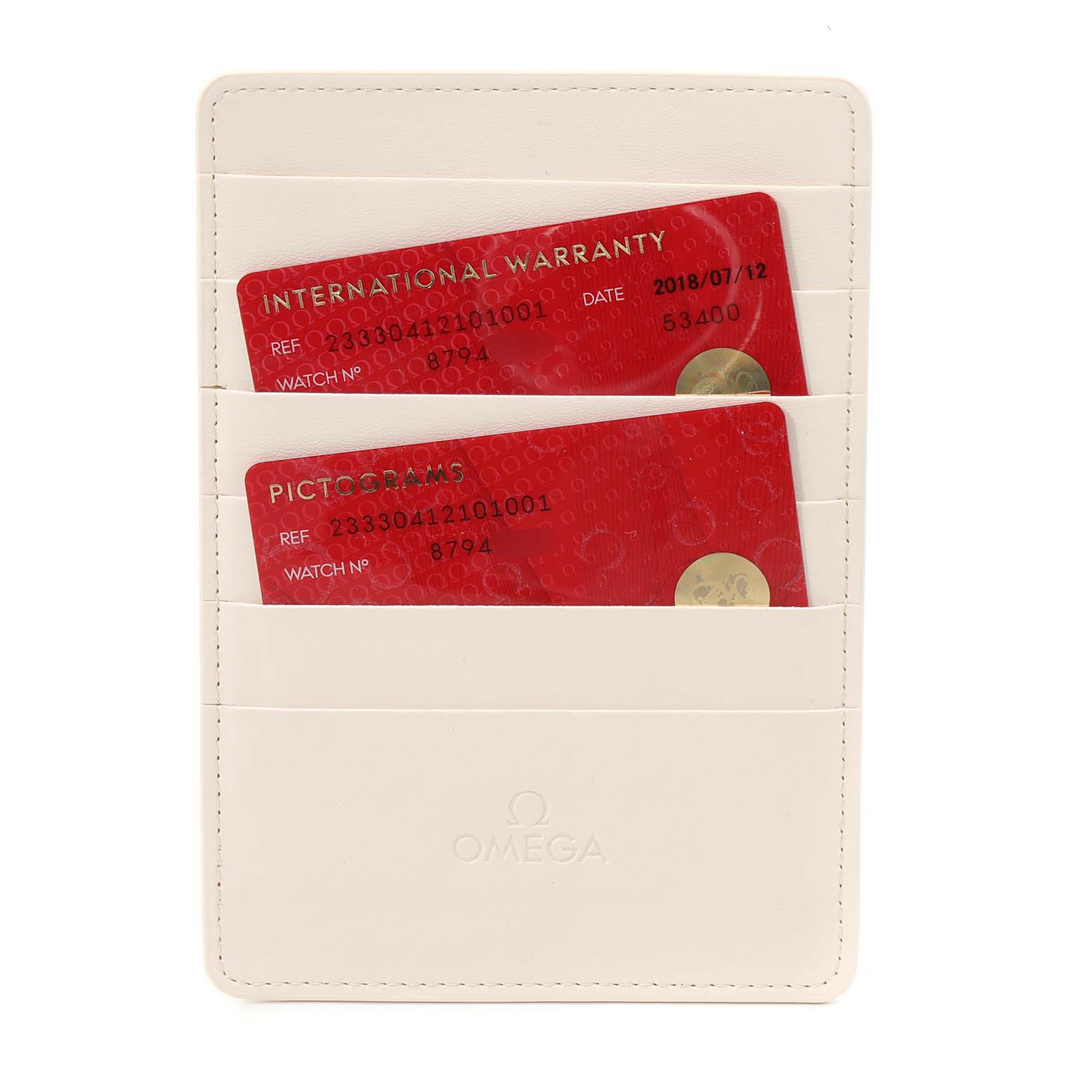 This image shows two red cards, International Warranty and Pictograms, in a white Omega holder for a Seamaster watch.