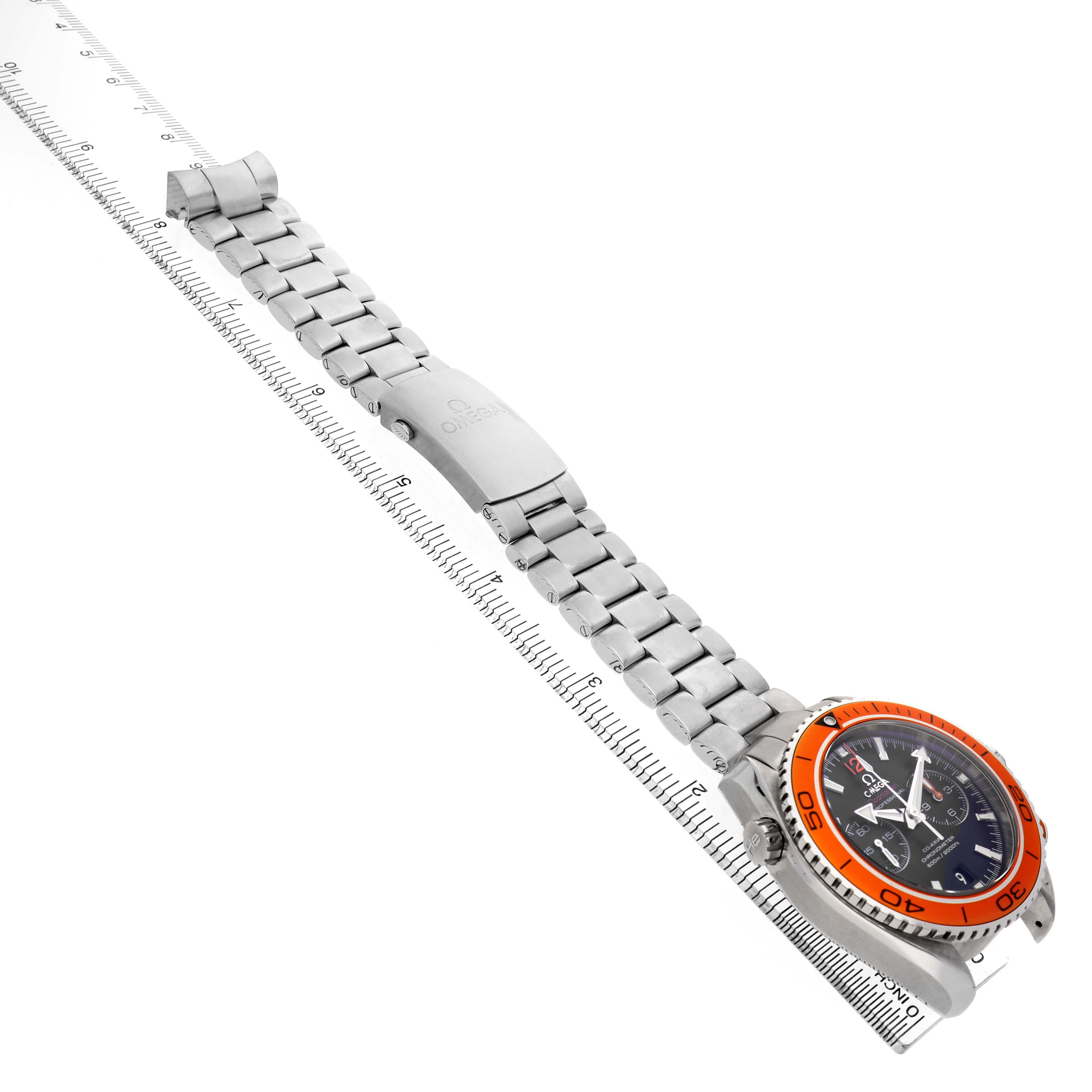 The Omega Planet Ocean 232.30.46.51.01.002 Men's Stainless Steel Black Dial watch is shown diagonally, highlighting the stainless steel bracelet and orange bezel.
