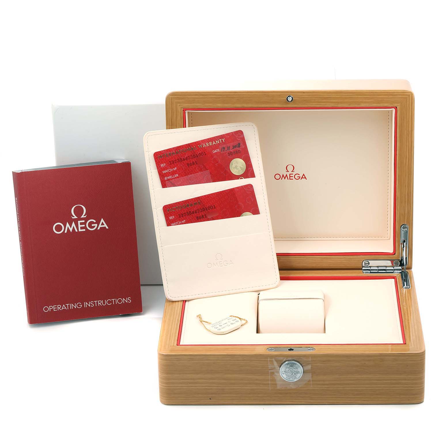 The image shows an Omega Planet Ocean 232.30.44.22.01.001 Men
s Stainless Steel Black Dial 232.30.44.22.01.001 Men
s Stainless Steel Black Dial watch box, operating instructions, warranty cards, and a tag.