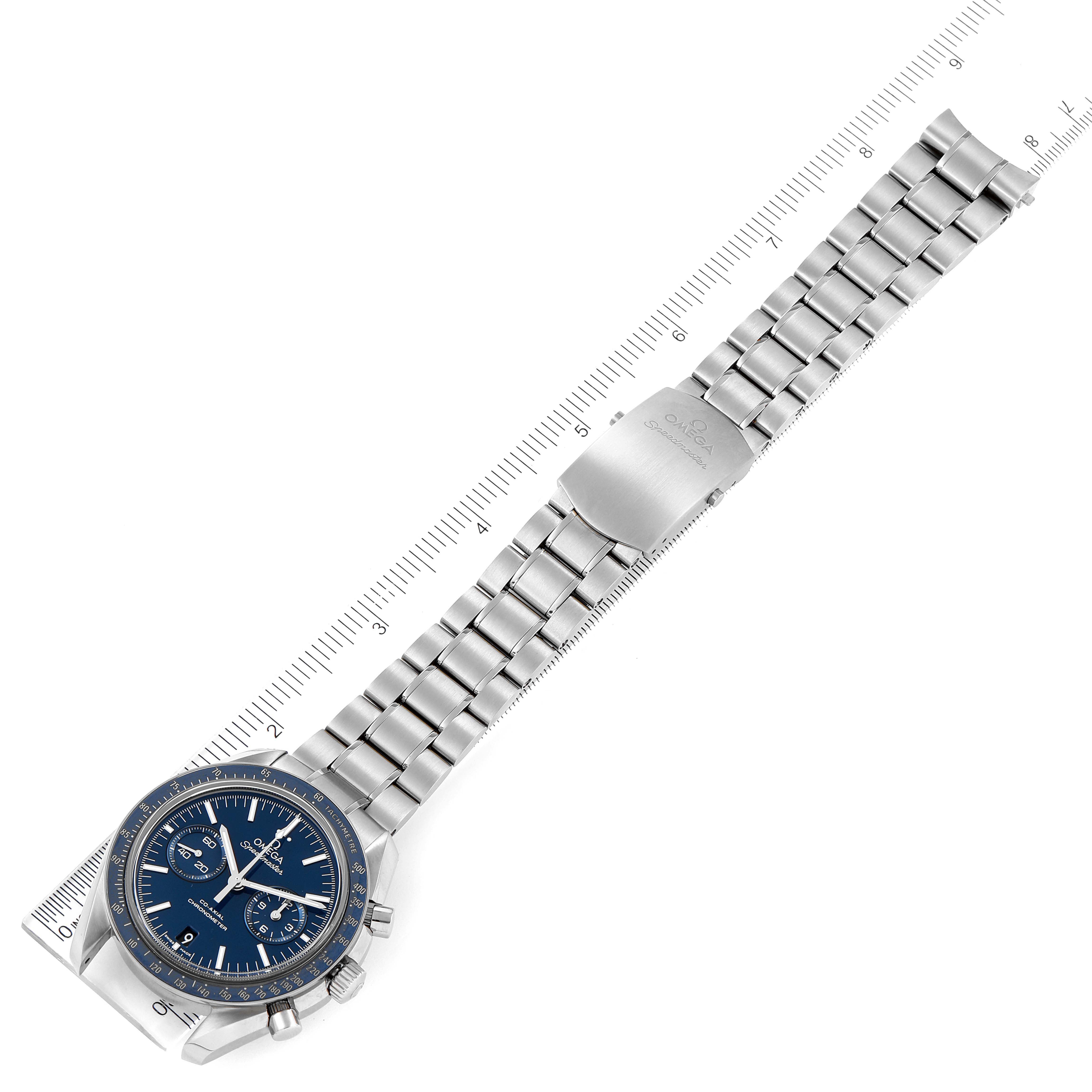 The Omega Speedmaster 311.90.44.51.03.001 Men's Titanium Blue Dial 311.90.44.51.03.001 Men's Titanium Blue Dial watch is displayed from an overhead angle, featuring its face, bezel, and metal bracelet with a ruler for scale.