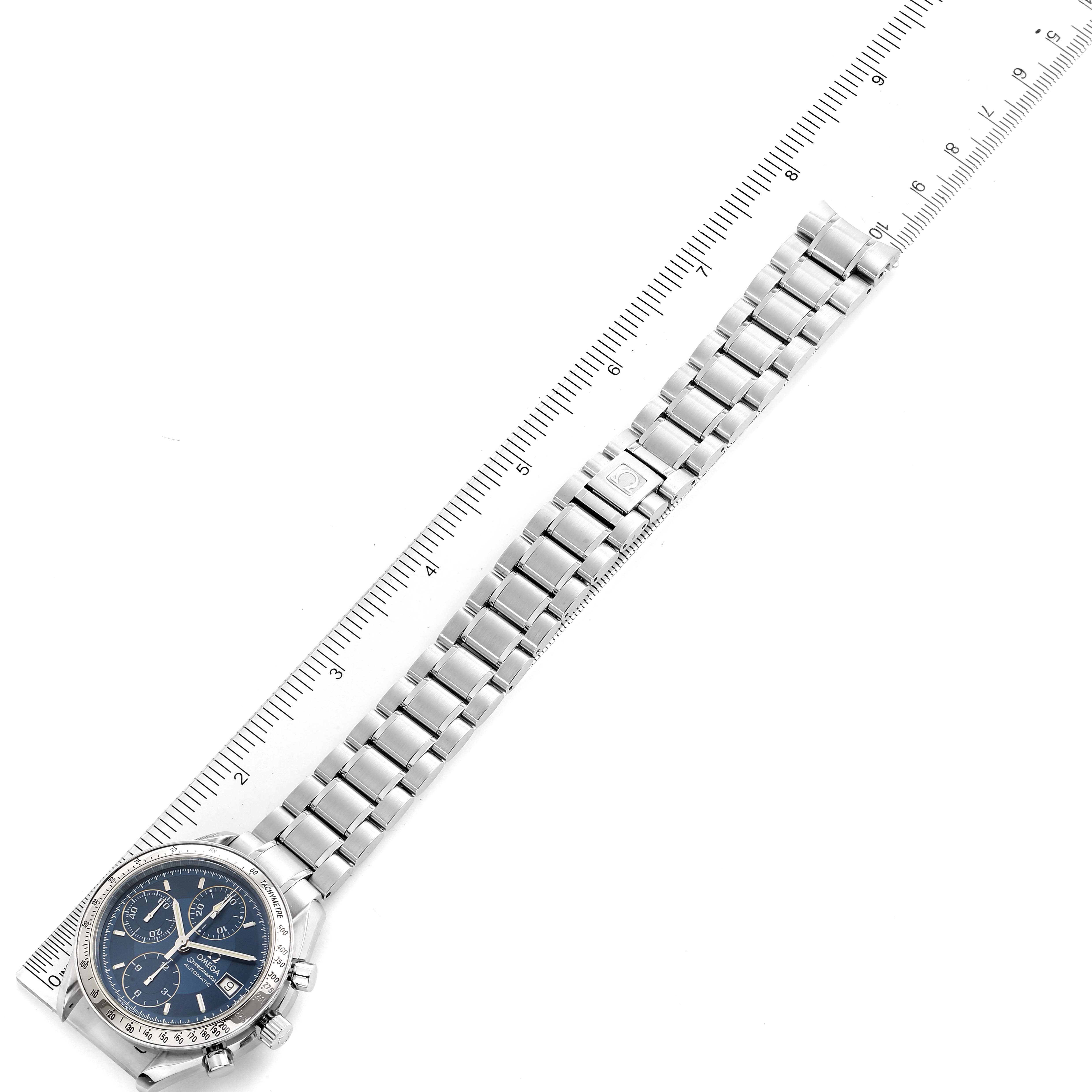 The image shows an Omega Speedmaster 3511.80.00 Men
s Stainless Steel Blue Dial 3511.80.00 Men
s Stainless Steel Blue Dial watch laid flat with a metal bracelet and a ruler for scale.