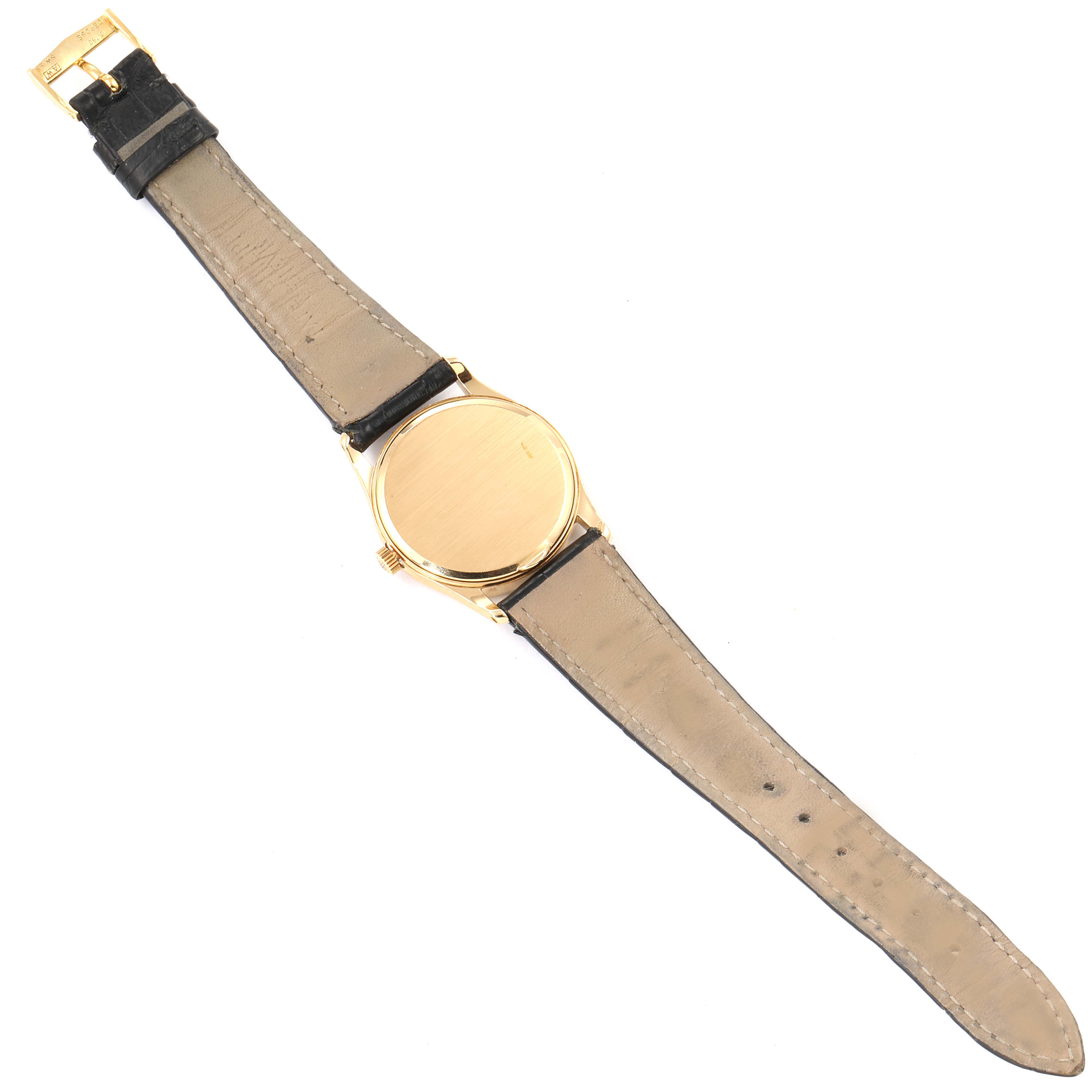 This image shows the back of a Vintage Patek Philippe watch, including the strap and buckle, at an overhead angle.