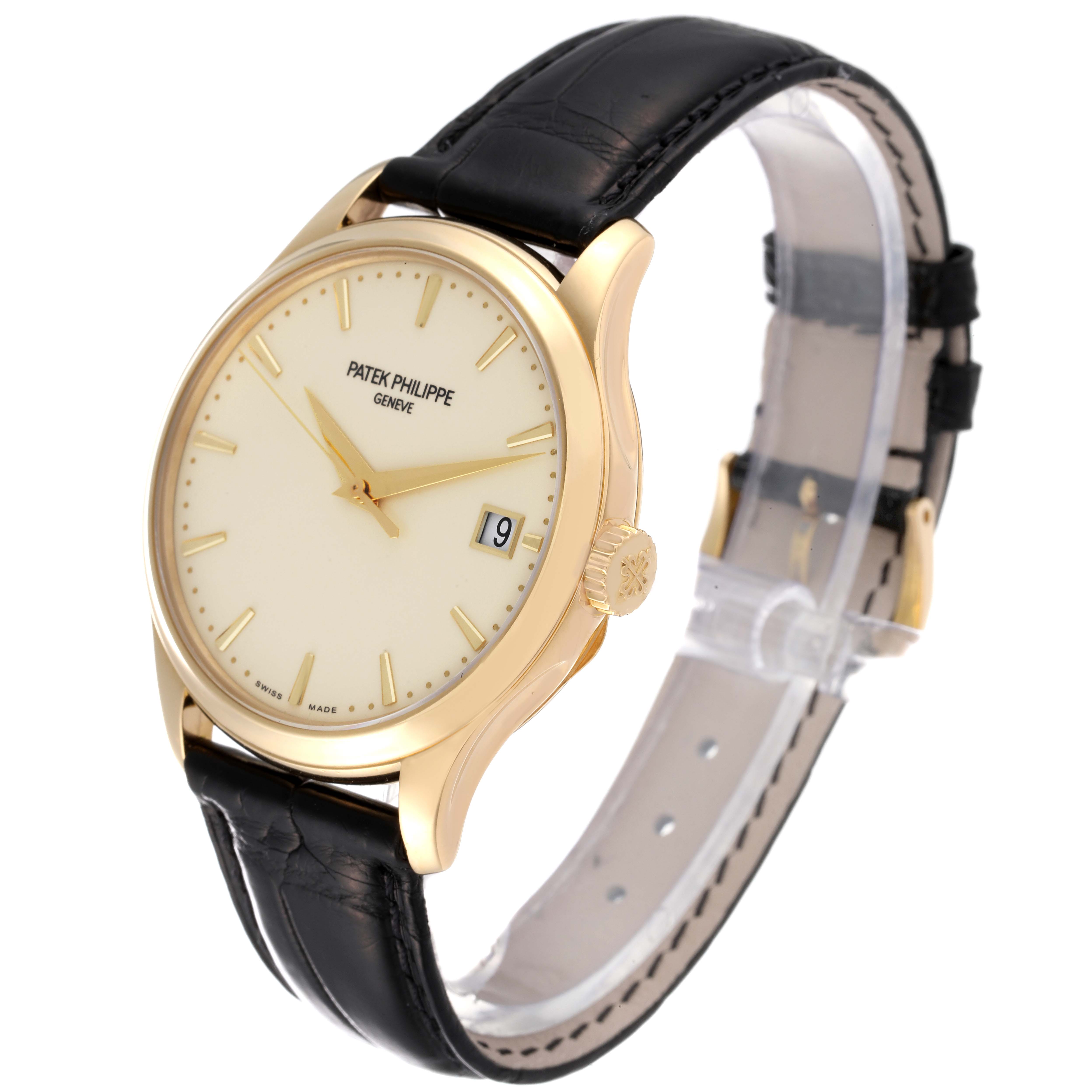 This image shows a Patek Philippe Calatrava 5227J-001 Men's Yellow Gold Beige Dial 5227J-001 Men's Yellow Gold Beige Dial watch at a slight angle, highlighting its face, crown, and black leather strap.