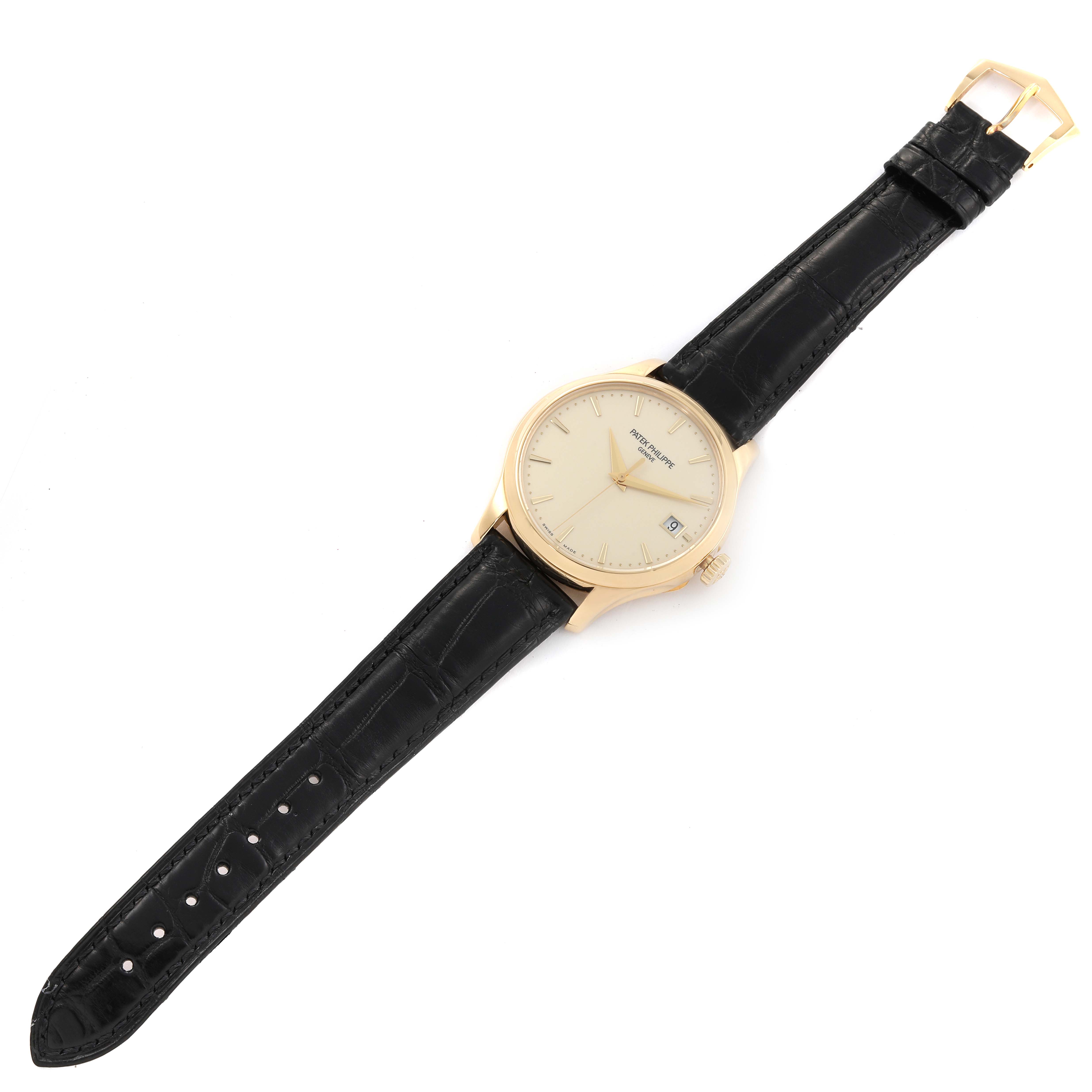 The image shows a top-down view of a Patek Philippe Calatrava 5227J-001 Men's Yellow Gold Beige Dial 5227J-001 Men's Yellow Gold Beige Dial watch with a black leather strap and gold case.