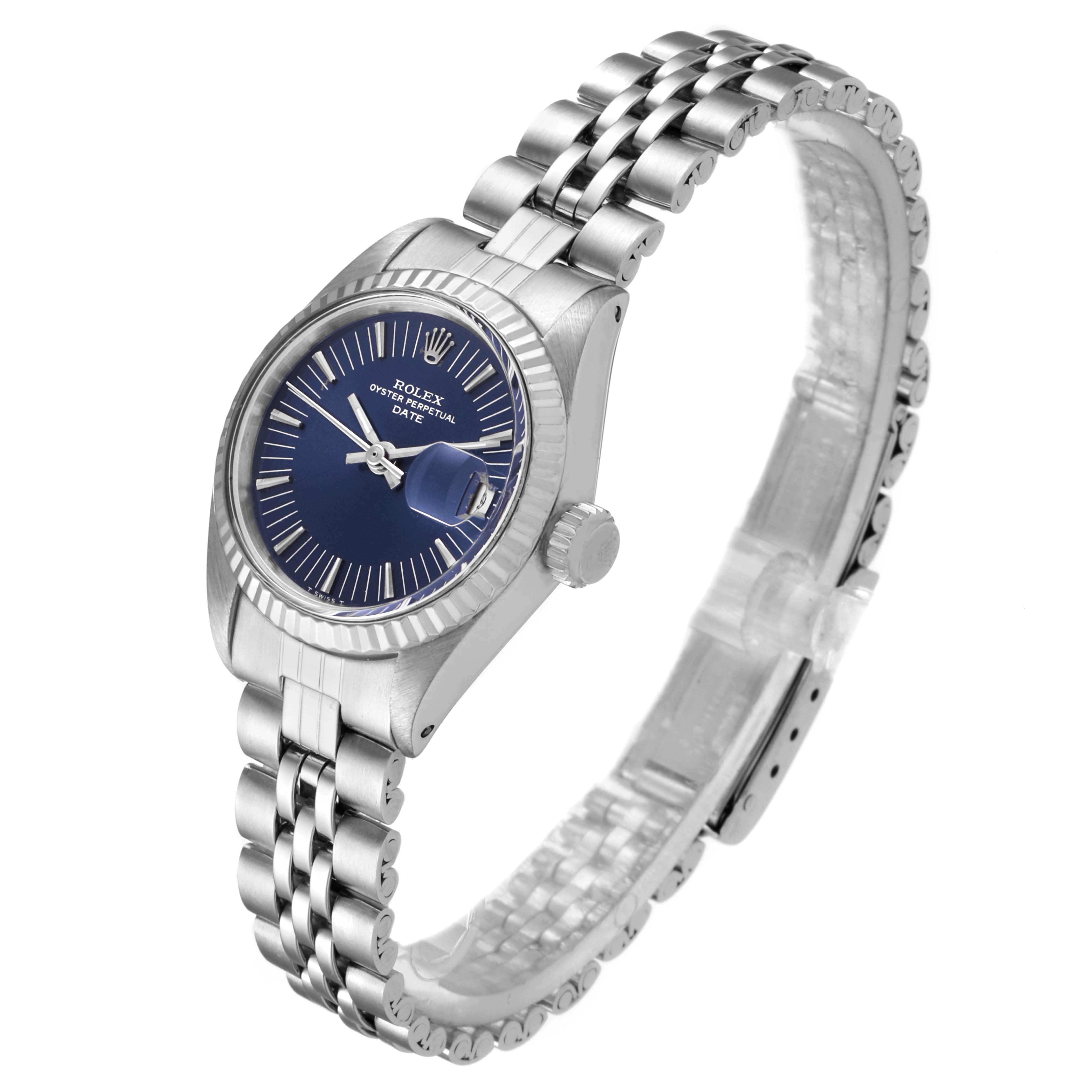 The image shows a side angle of a Rolex Date 6917 Women's Stainless Steel Blue Dial 6917 Women's Stainless Steel Blue Dial model watch featuring its face, bezel, and part of the bracelet.
