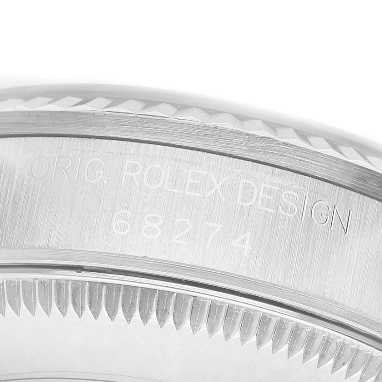 The image shows a close-up of the side of a Rolex Mid-Size 68274 Women's Stainless Steel Black Dial model 68274, featuring its engraved design details and fluted bezel.