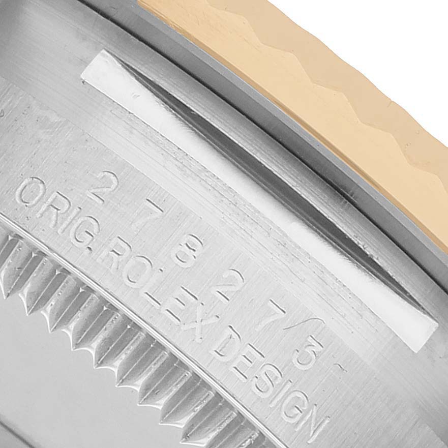 The image shows a close-up of the Rolex Datejust 278273 Men's Steel and Gold (two tone) Champagne Dial's case edge with engravings and part of the bezel.