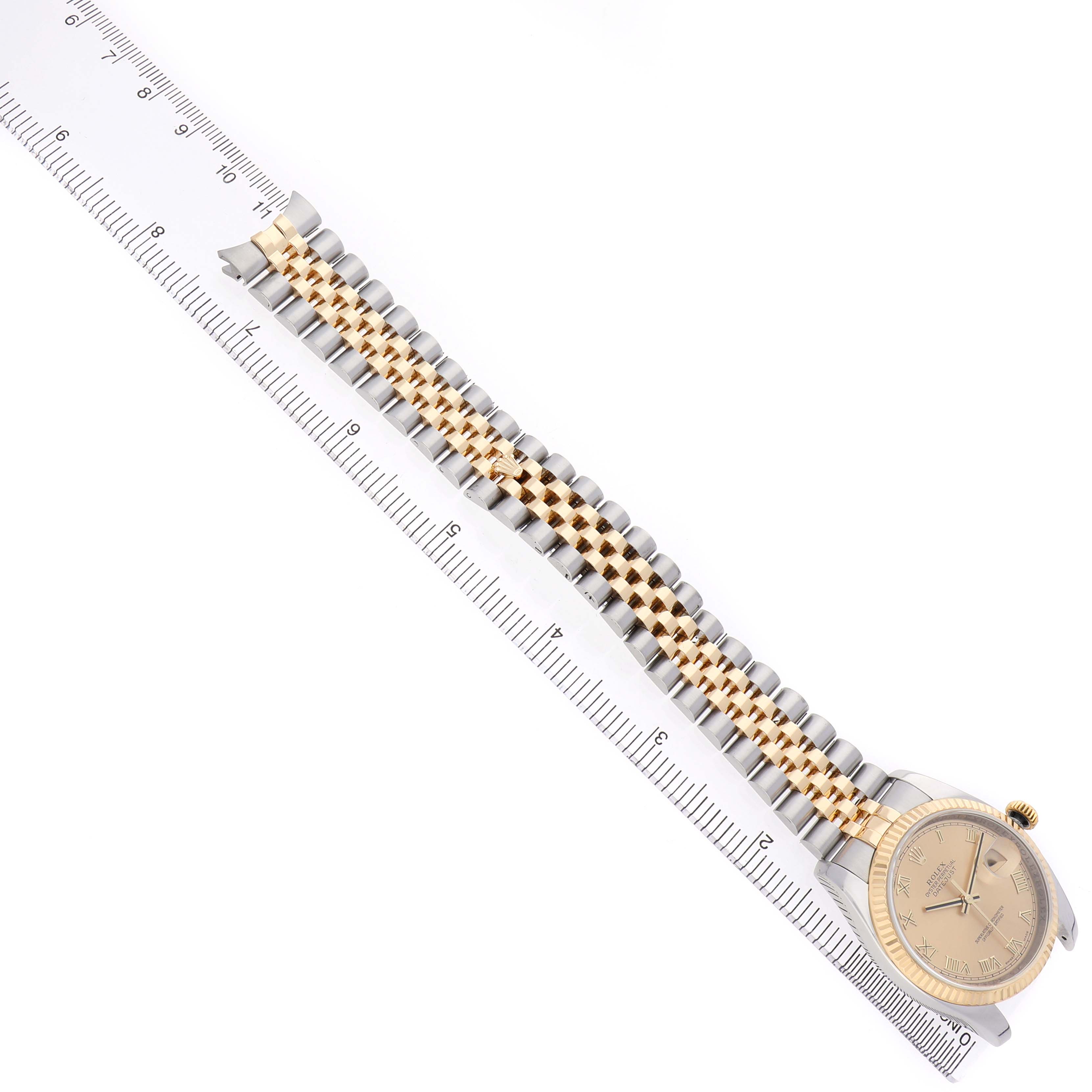 The Rolex Datejust 116233 Men's Stainless Steel Champagne Dial watch is shown from an overhead angle, highlighting its bracelet and face alongside a ruler for scale.