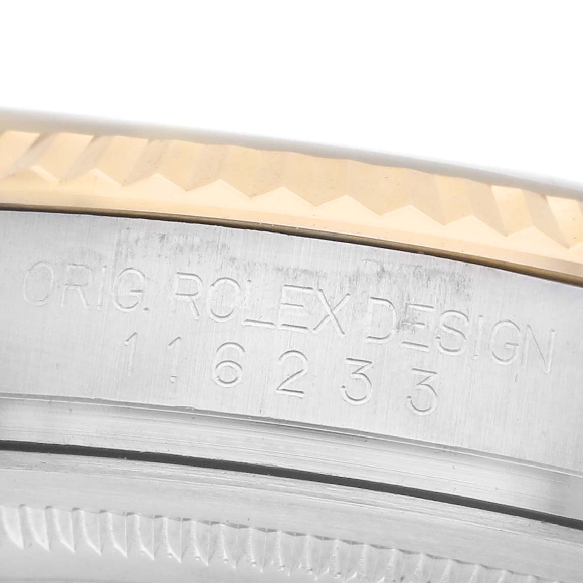 The image shows a close-up of the side view of a Rolex Datejust 116233 Men's Stainless Steel Champagne Dial, focusing on the engraved model number and bezel edge.