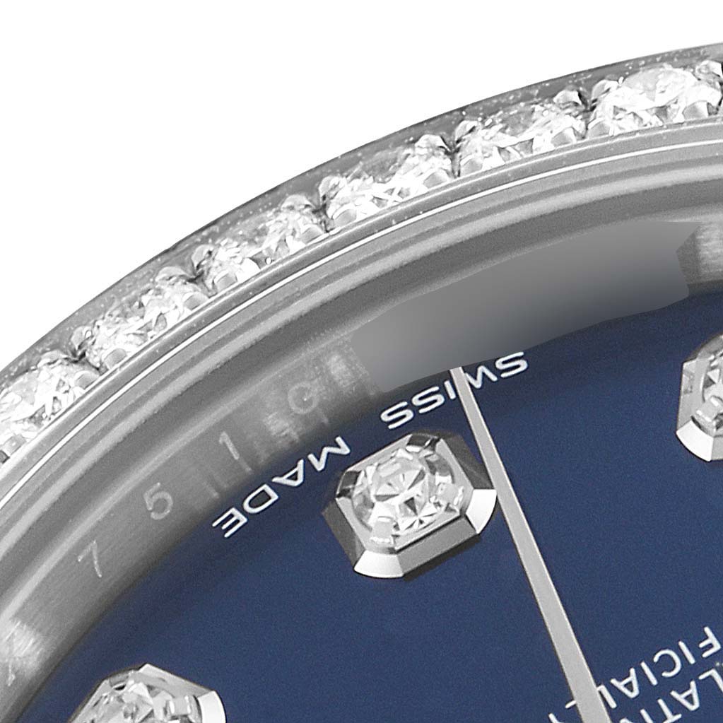This close-up of a Rolex Mid-Size 178384 Women
s Stainless Steel Blue Dial 178384 Women
s Stainless Steel Blue Dial watch shows the diamond-encrusted bezel and part of the blue dial with diamond hour markers.