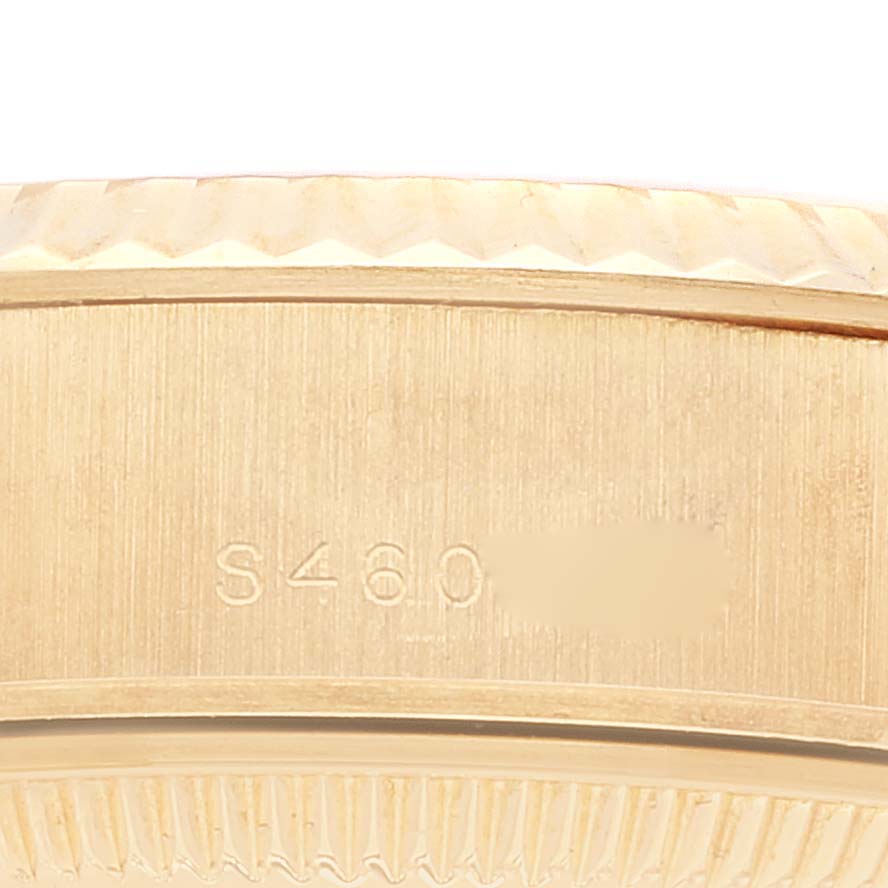 This close-up image shows the side of a Rolex President 69178 Women
s Yellow Gold Champagne Dial 69178 Women
s Yellow Gold Champagne Dial model watch, featuring part of the serial number engraving and the fluted bezel.