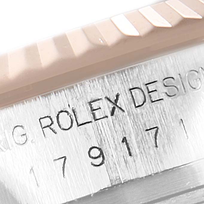 This close-up of the Rolex Datejust 179171 Women's Steel and Gold (two tone) Mother of Pearl Dial 179171 Women's Steel and Gold (two tone) Mother of Pearl Dial watch shows the fluted bezel and engraved serial number on the case.