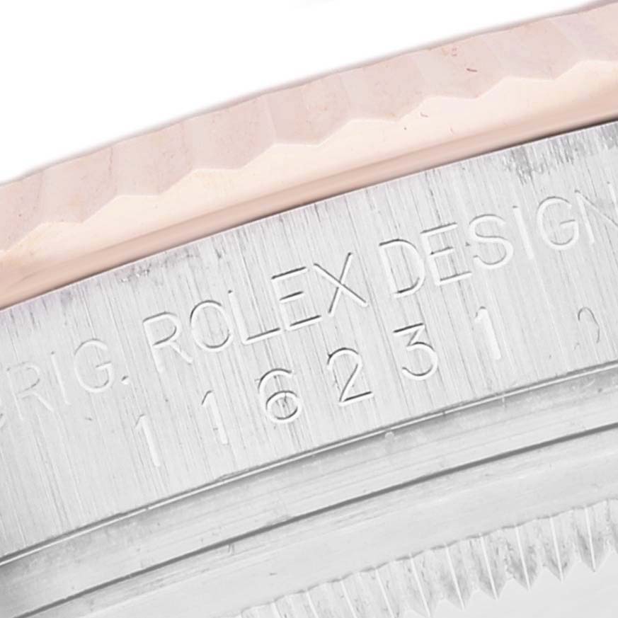 The image shows a close-up view of the engraved serial number and fluted bezel on a Rolex Datejust 116231 Men's Steel and Gold (two tone) White Dial 116231 Men's Steel and Gold (two tone) White Dial model watch.
