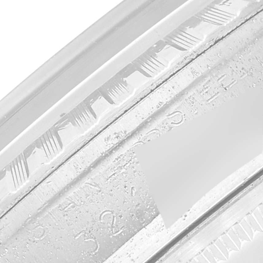 The image shows a close-up of the engraved serial number and bezel detail of the Vintage Collection model by Rolex.