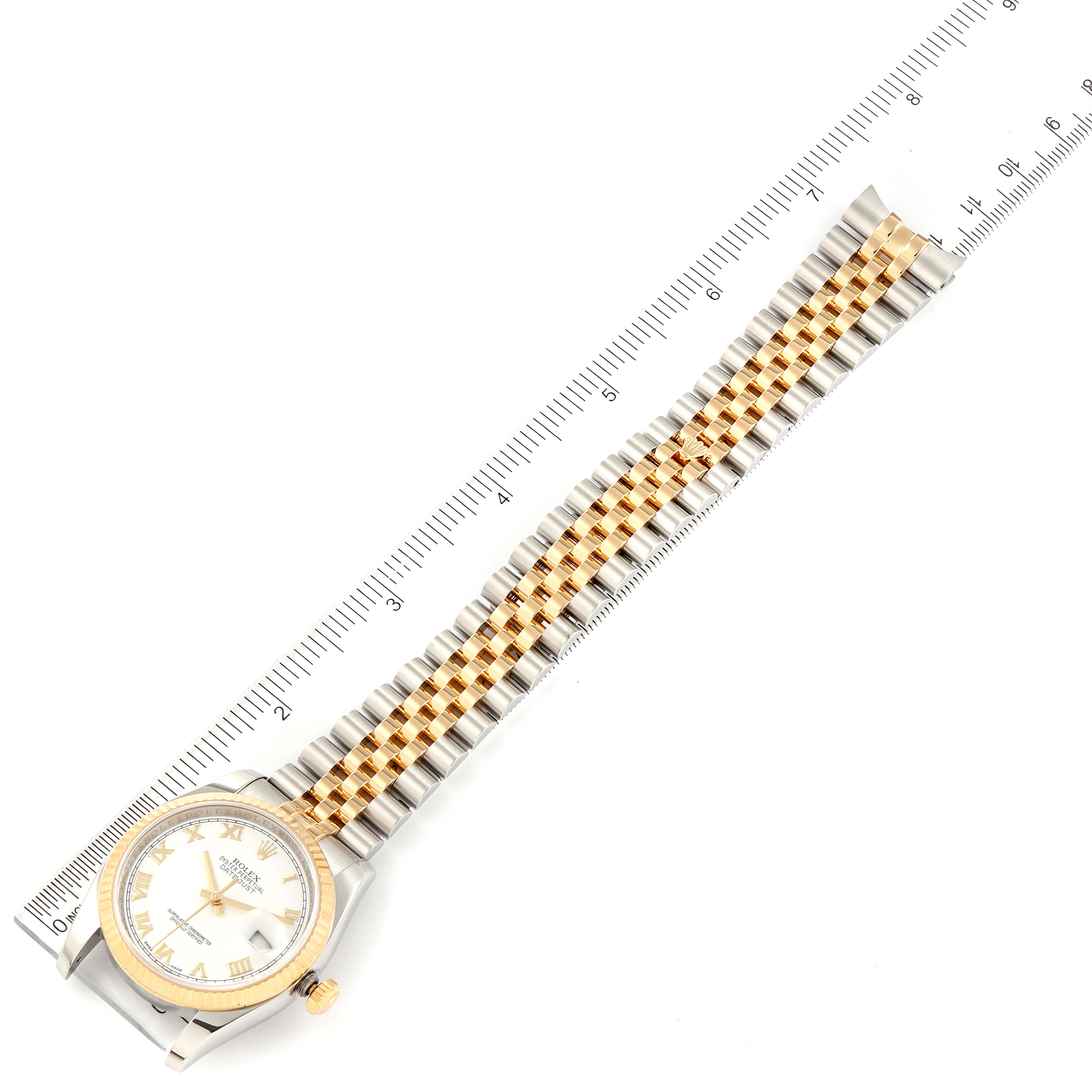This image shows a Rolex Datejust 116233 Men's Steel and Gold (two tone) White Dial 116233 Men's Steel and Gold (two tone) White Dial watch laid flat next to a ruler, focusing on the entire band and watch face from a top-down angle.