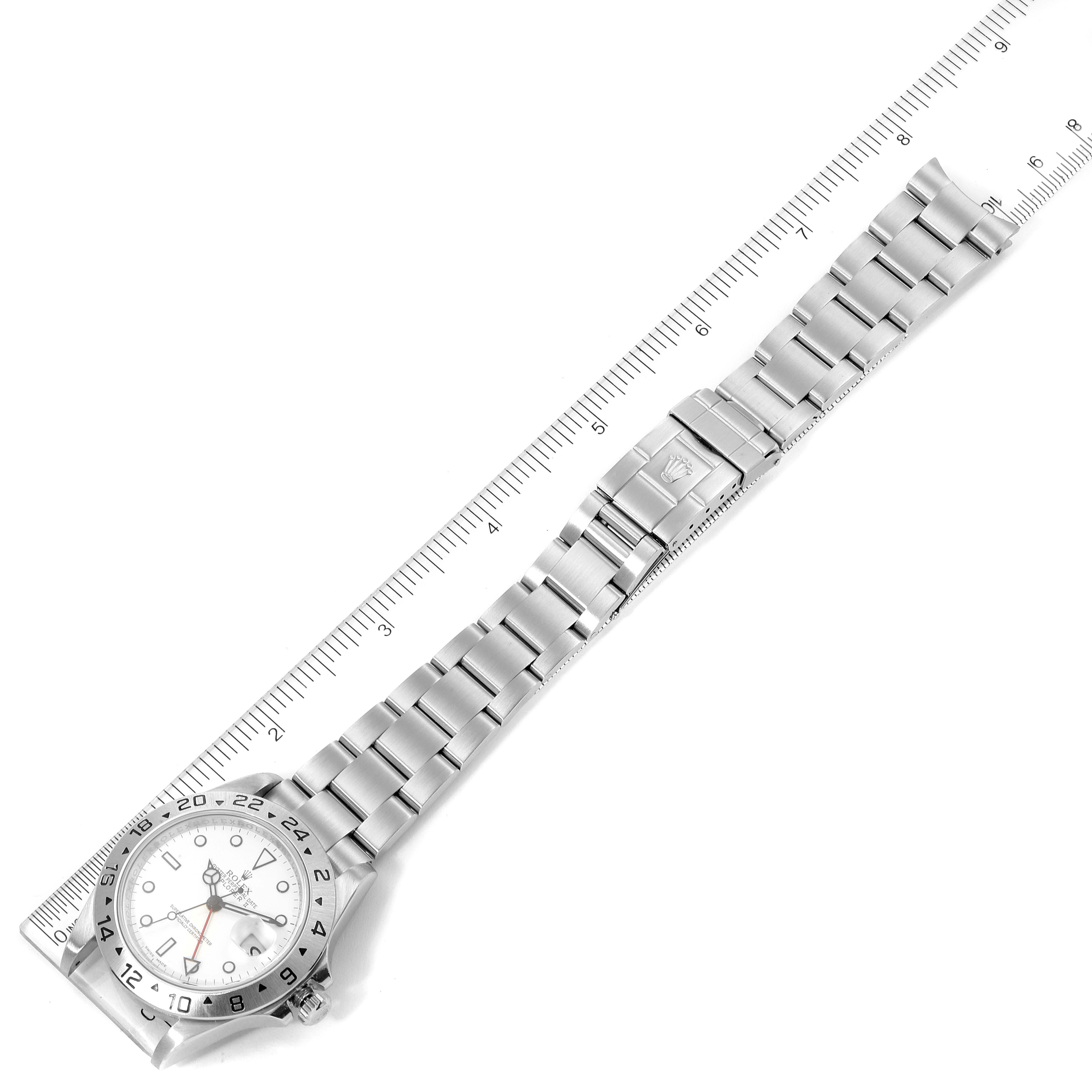 The image shows a top-down view of a Rolex Explorer 16570 Men's Stainless Steel White Dial 16570 Men's Stainless Steel White Dial watch, displaying the face, bezel, and bracelet, with a ruler for scale.