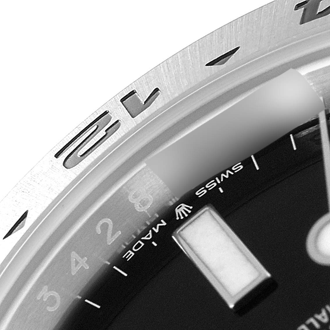 This close-up of the Rolex Explorer 226570 Men's Stainless Steel Black Dial 226570 Men's Stainless Steel Black Dial watch focuses on part of the bezel, dial, and the "Swiss Made" text.
