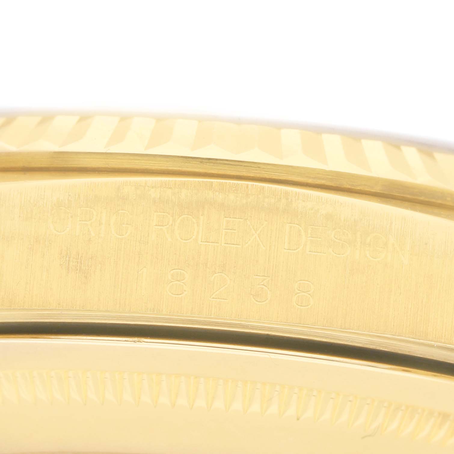 The image shows a close-up of the side of a Rolex President 18238 Men's Yellow Gold Champagne Dial model, featuring the bezel and engraved design details.