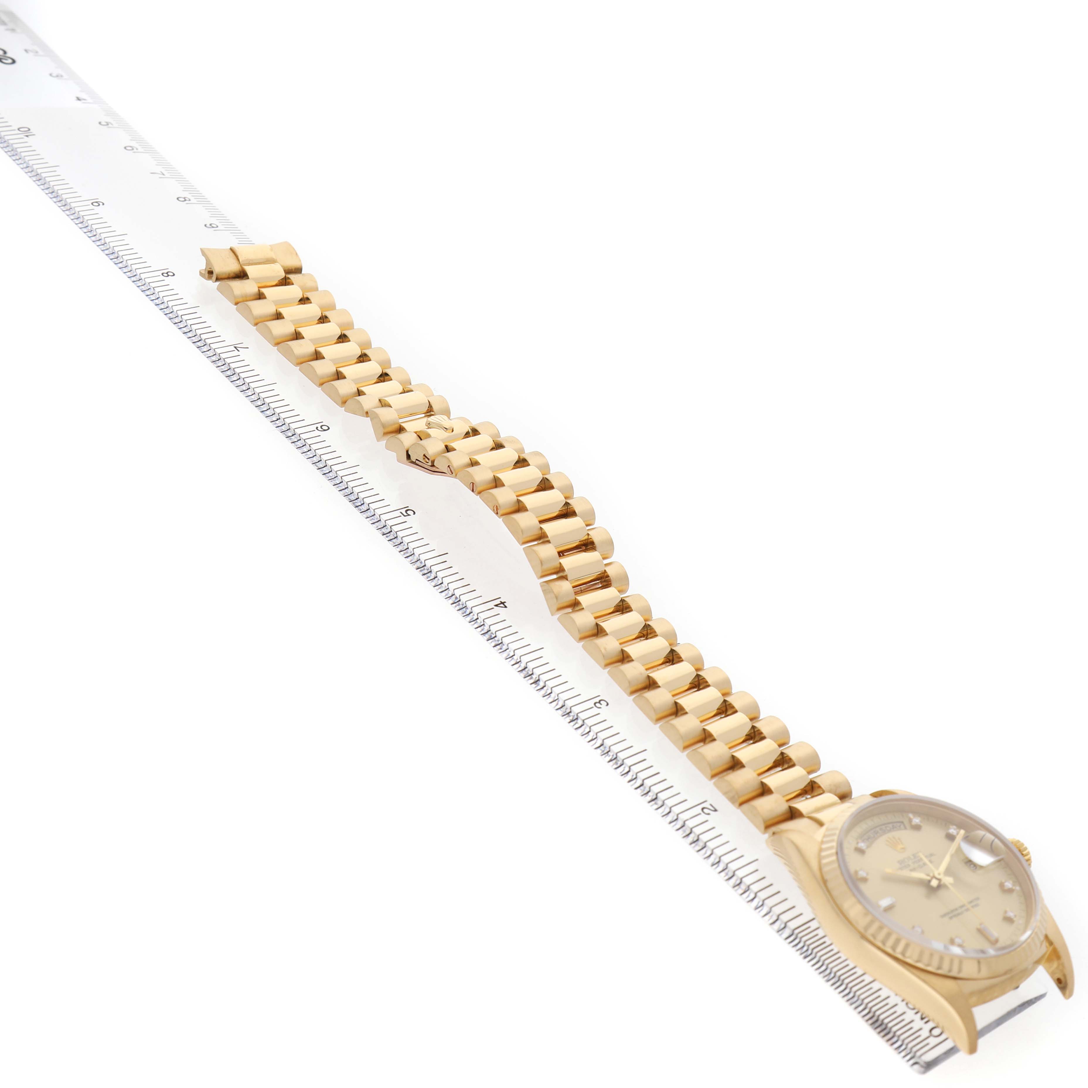 The Rolex President 18238 Men's Yellow Gold Champagne Dial watch is shown from a side angle, highlighting the face and full bracelet length with a ruler for scale.