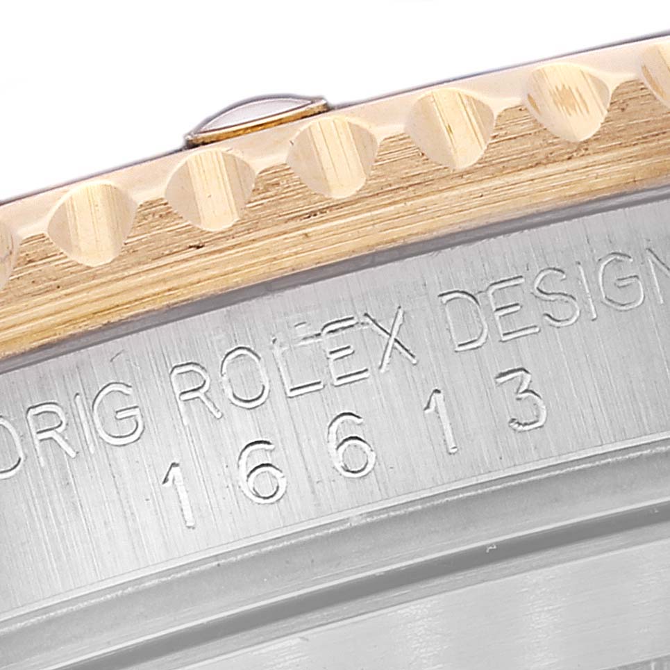 This close-up image shows the Rolex Submariner 16613 Men's Steel and Gold (two tone) Blue Dial 16613 Men's Steel and Gold (two tone) Blue Dial model 16613's side engraving and edge of the bezel.