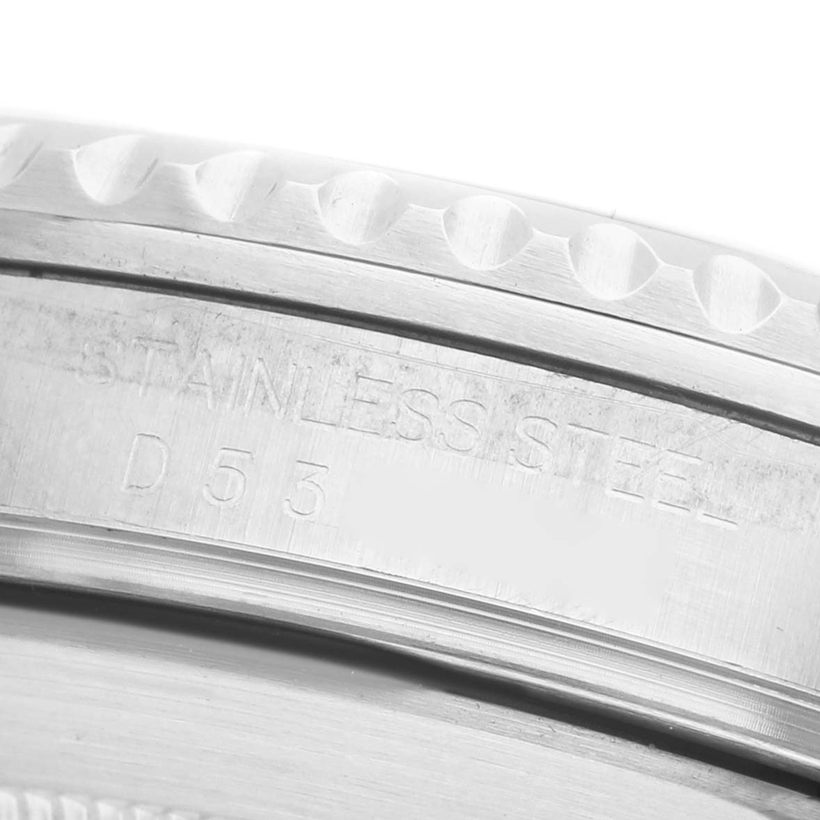 The image shows a close-up of the engraved side of the bezel and casing, featuring "STAINLESS STEEL," on a Rolex Submariner 16610 Men's Stainless Steel Black Dial.