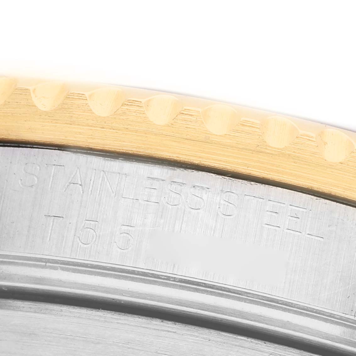 The image shows a close-up of the Rolex Submariner 16613 Men's Steel and Gold (two tone) Champagne Dial's bezel edge and part of the stainless steel case back with engraved text.