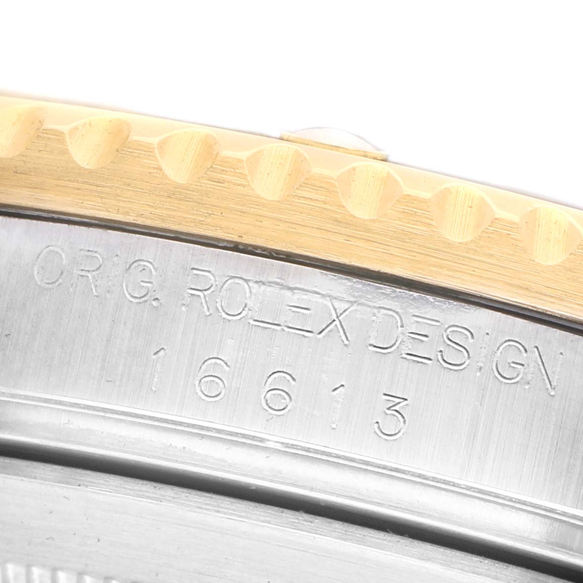 The image shows a close-up of the engraving on the side of the Rolex Submariner 16613 Men's Steel and Gold (two tone) Champagne Dial case.