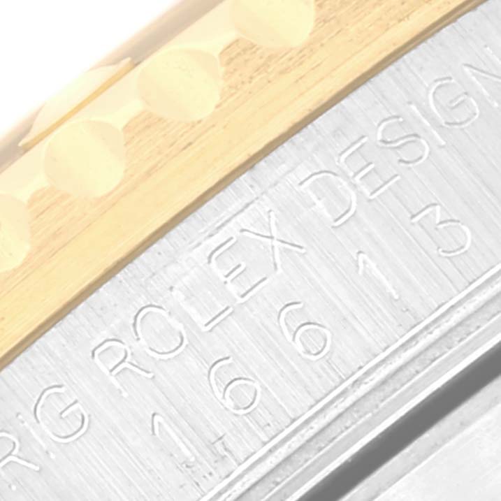 The image shows an angled close-up of the side of a Rolex Submariner 16613 Men's Steel and Gold (two tone) Black Dial 16613 Men's Steel and Gold (two tone) Black Dial, highlighting the engravings and part of the bezel.