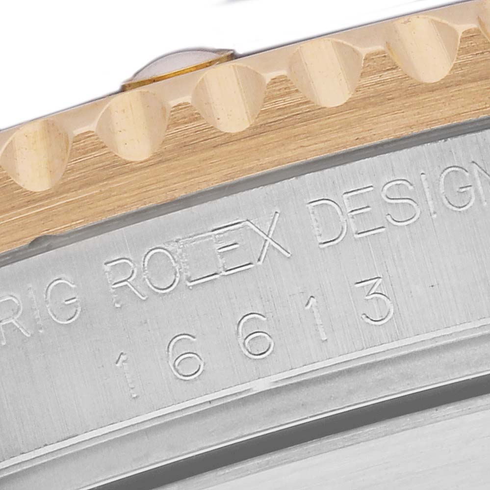This close-up image shows the engraved case side and bezel teeth of a Rolex Submariner 16613 Men's Steel and Gold (two tone) Grey Dial 16613 Men's Steel and Gold (two tone) Grey Dial model watch.