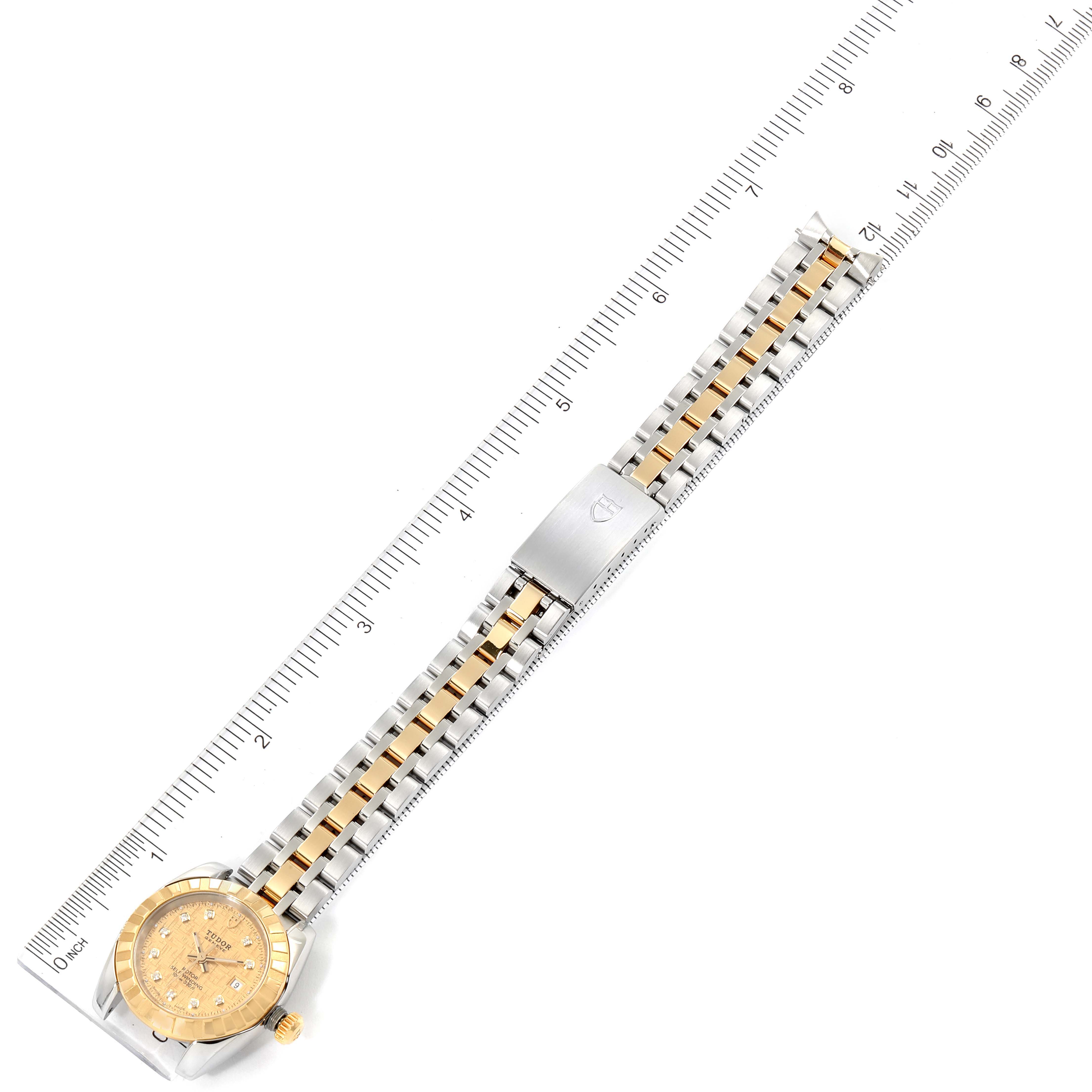 The Classic model by Tudor is shown from a top-down view with focus on its bracelet and dial, aligned with a ruler.