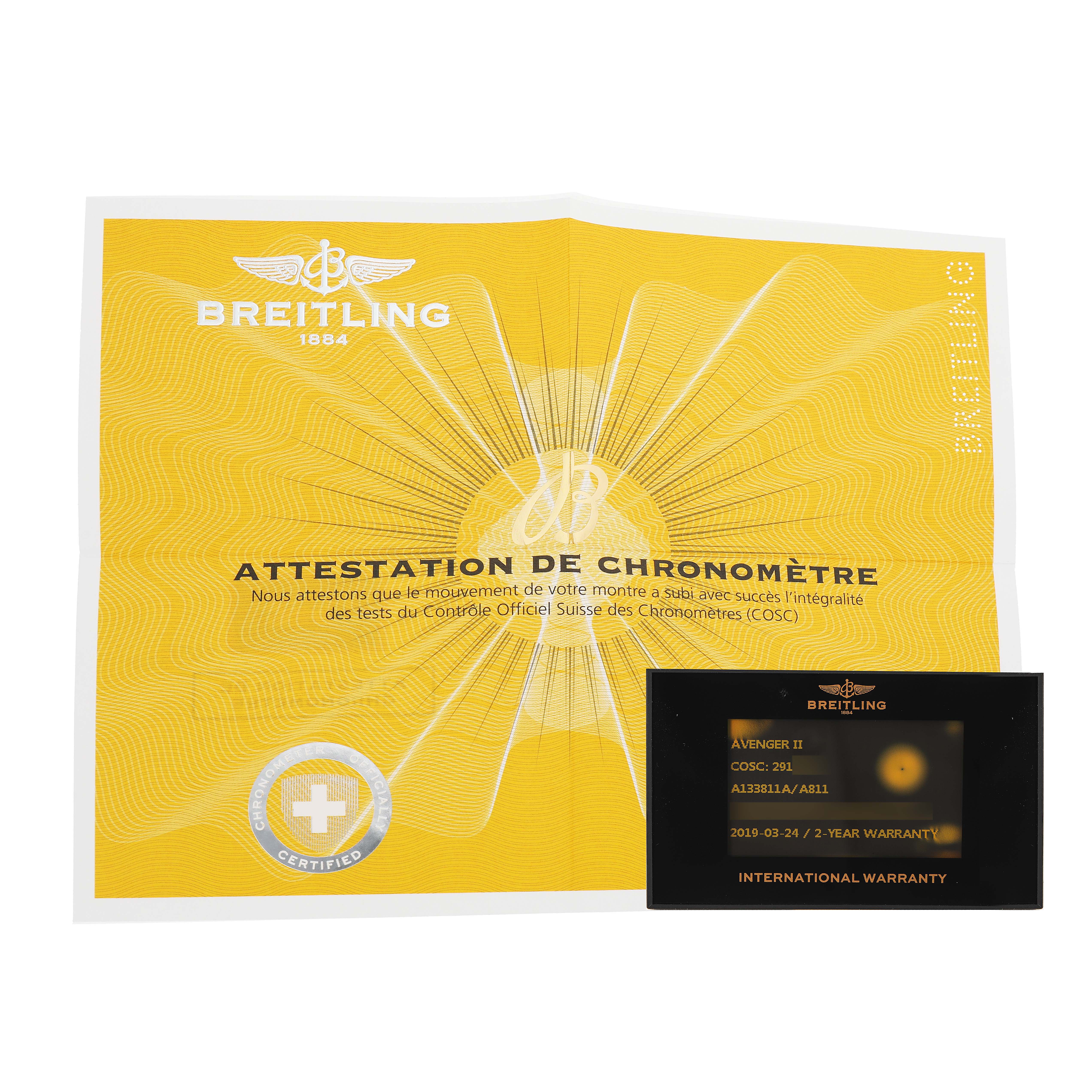 The image shows a Breitling Avenger A13381 Men's Stainless Steel White Dial model's certification paper and international warranty card from a top-down angle.