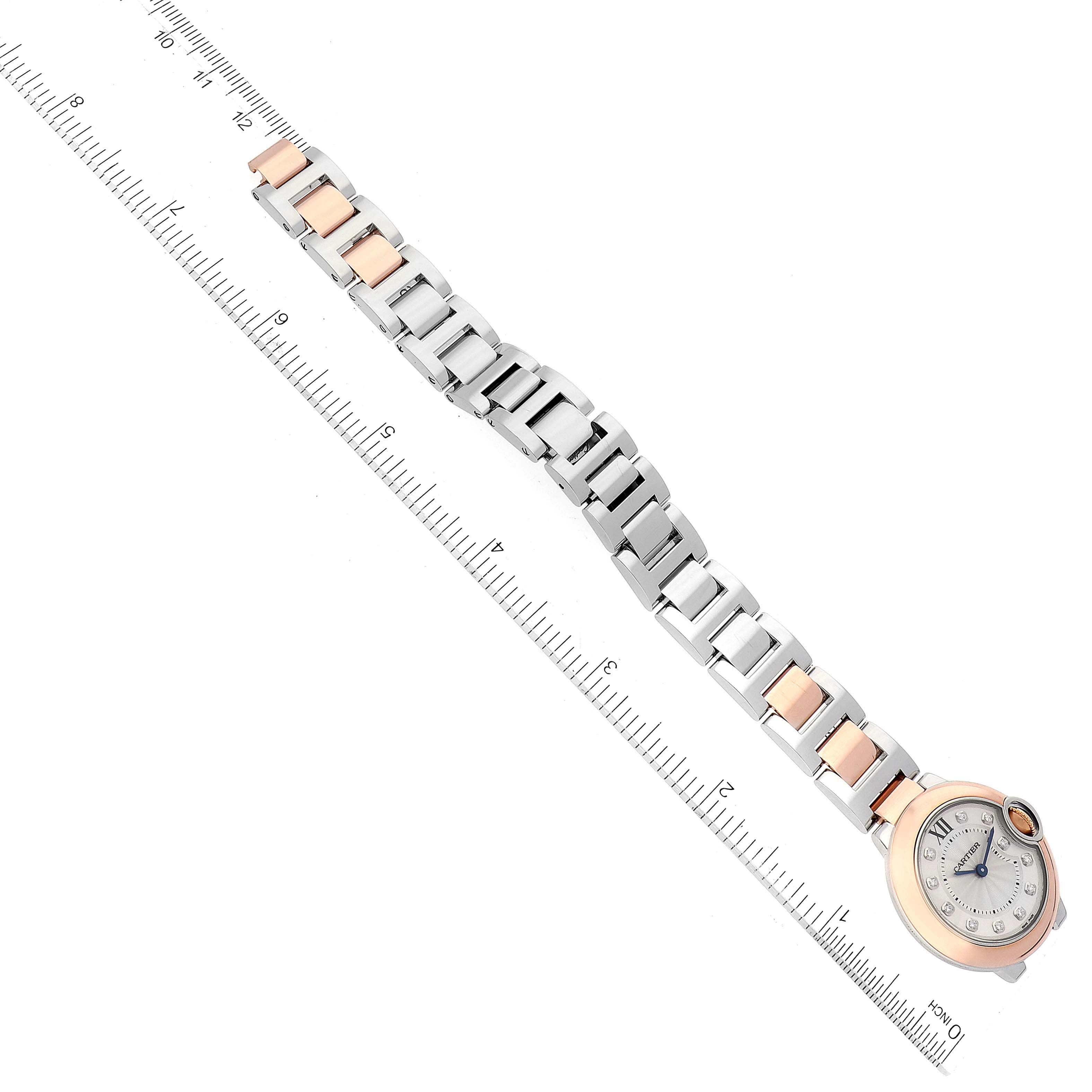 The Ballon Bleu watch by Cartier is shown from an overhead angle, highlighting its full band and face beside a ruler for scale.