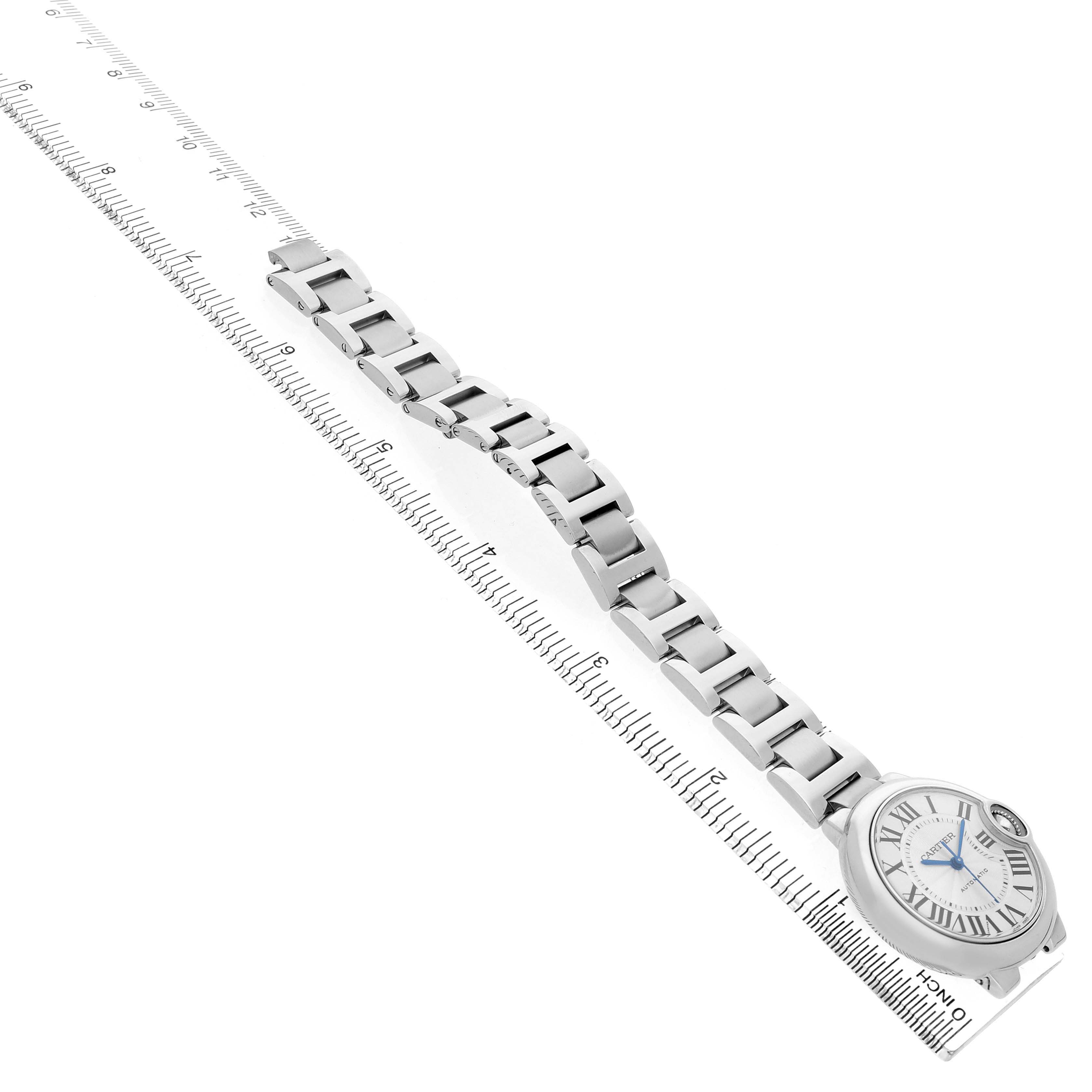 The Cartier Ballon Bleu W6920071 Women's Stainless Steel Silver Dial watch is shown at a diagonal angle with a focus on the face and bracelet, aligned with a ruler.