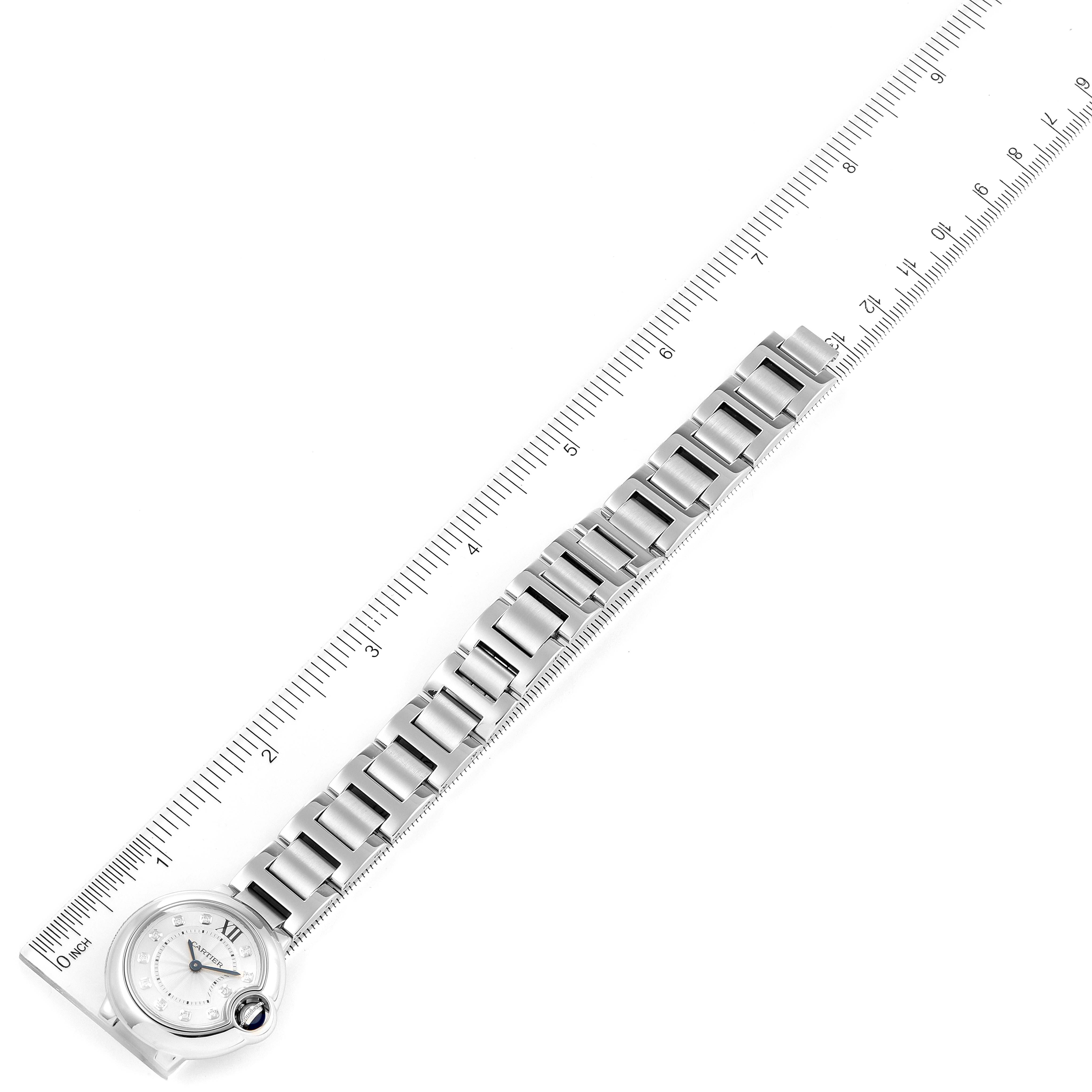 The image shows the Ballon Bleu de Cartier watch laying flat with its face and full metal bracelet displayed alongside a ruler.