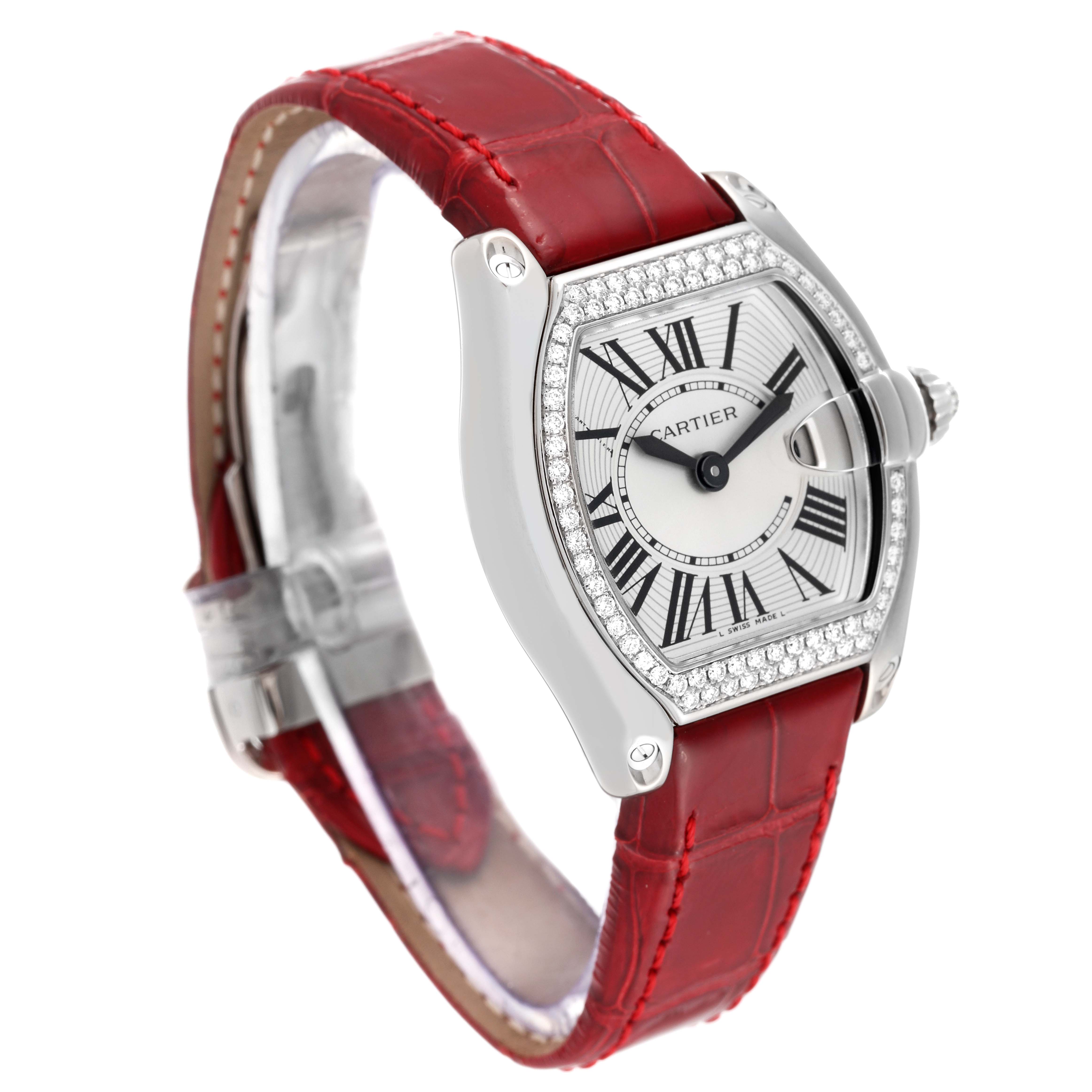 The Cartier Roadster WE500260 Women's White Gold Silver Dial WE500260 Women's White Gold Silver Dial watch is shown from a three-quarter angle, detailing its face, red band, and diamond-encrusted bezel.