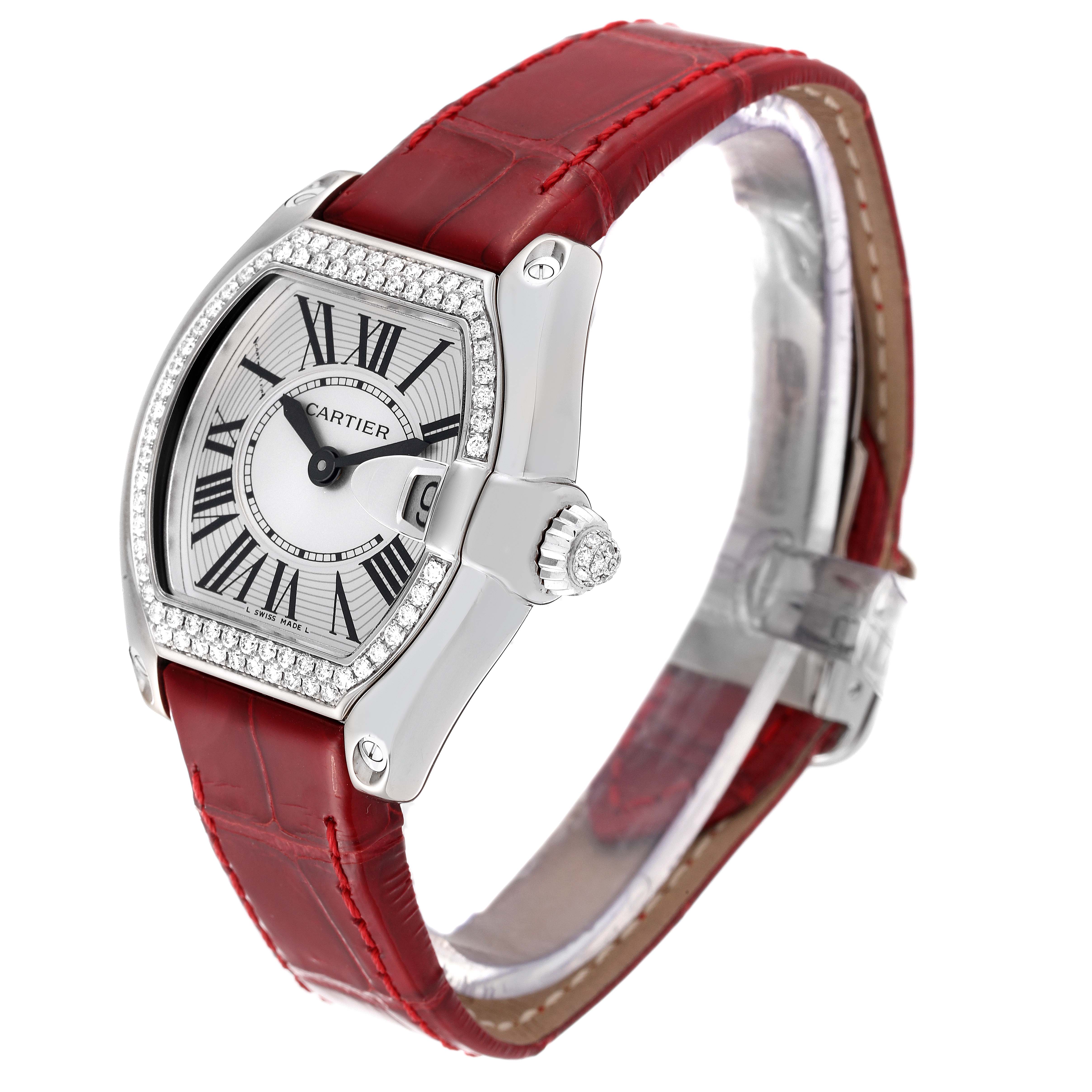 The Cartier Roadster WE500260 Women's White Gold Silver Dial WE500260 Women's White Gold Silver Dial watch is shown from a front-right angle, highlighting its red leather band and diamond-encrusted bezel.