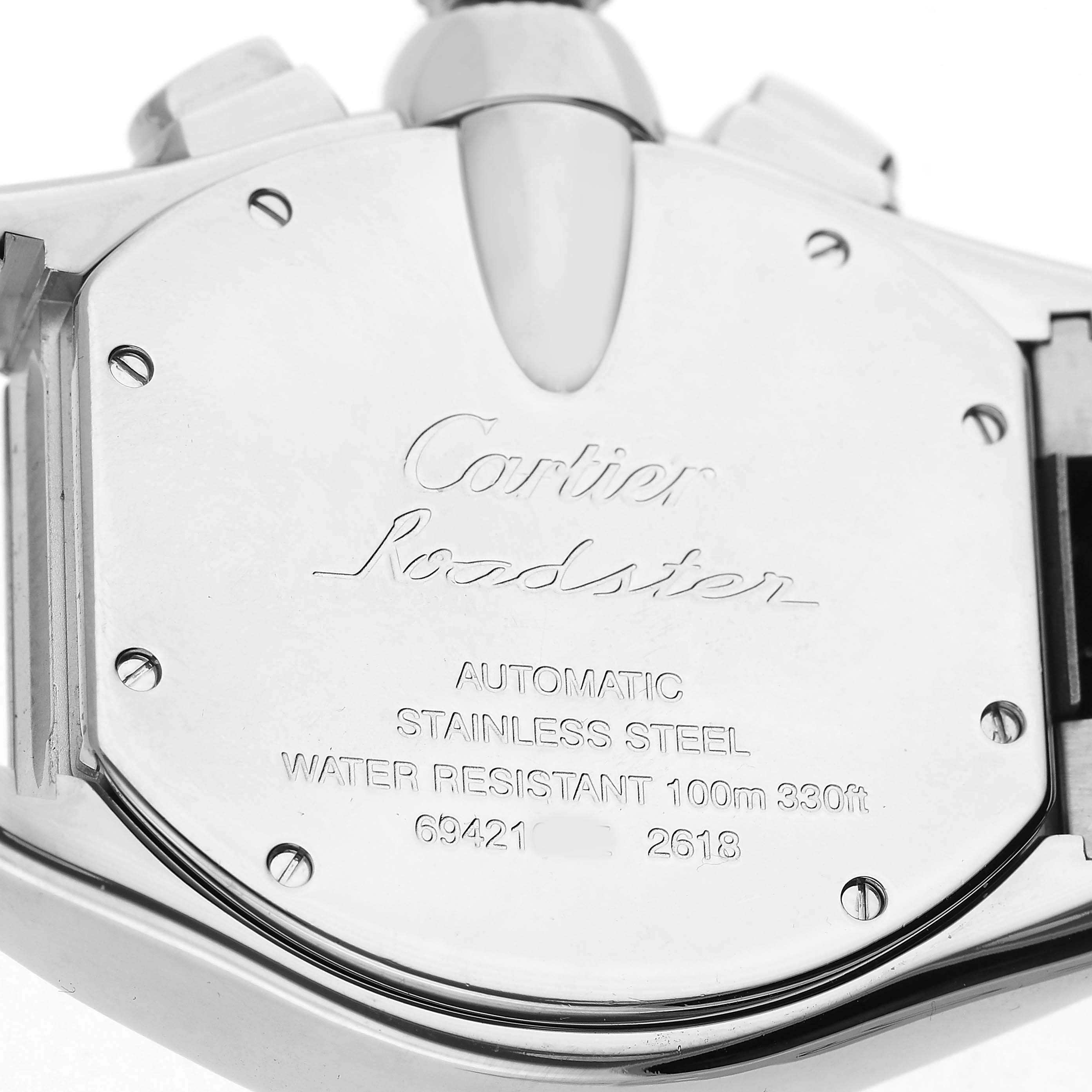 The image shows the back of a Cartier Roadster W62019X6 Men's Stainless Steel Silver Dial watch, highlighting the engravings and stainless steel case.