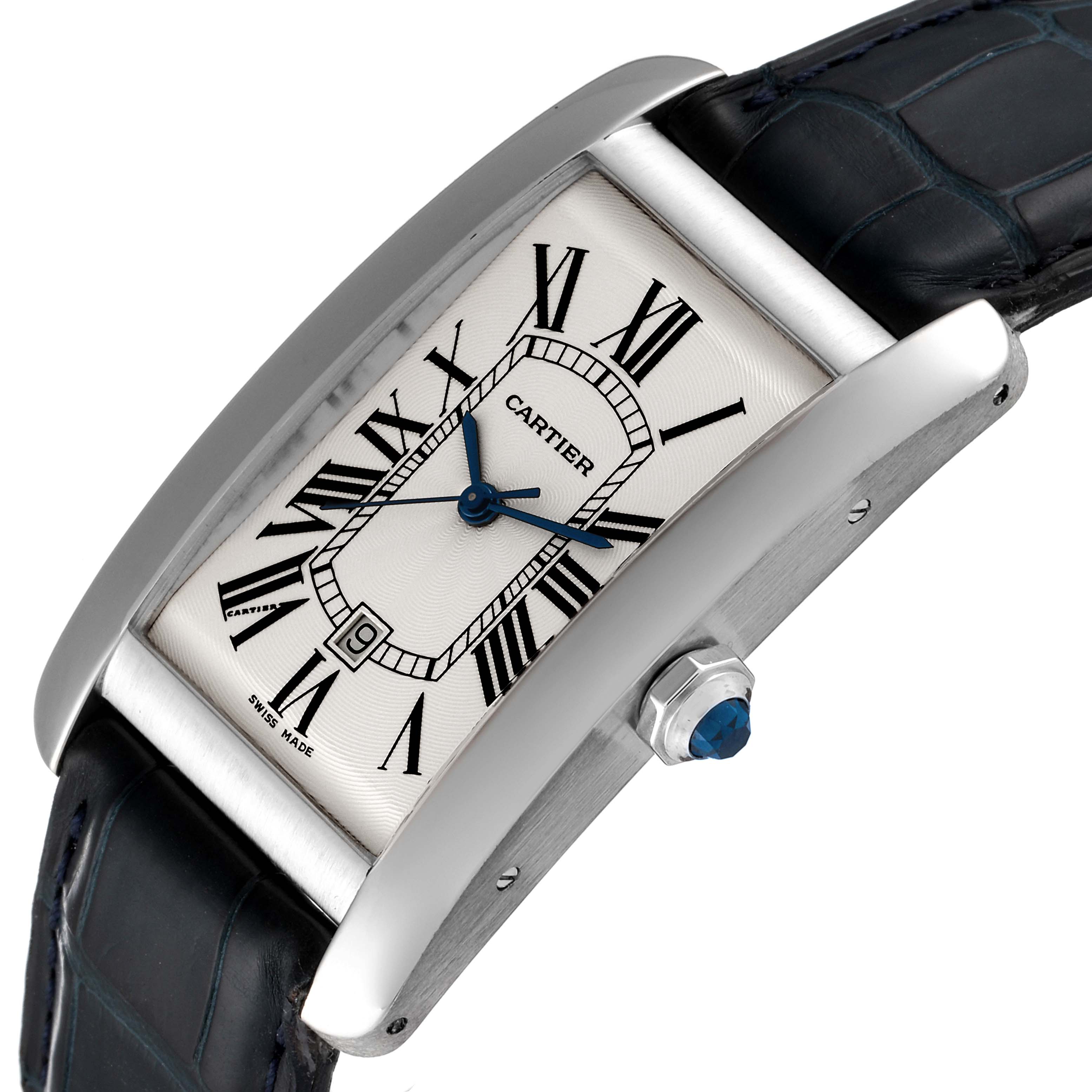 The image shows a side angle view of a Cartier Tank Américaine watch, highlighting its dial, case, and crown with a blue stone.