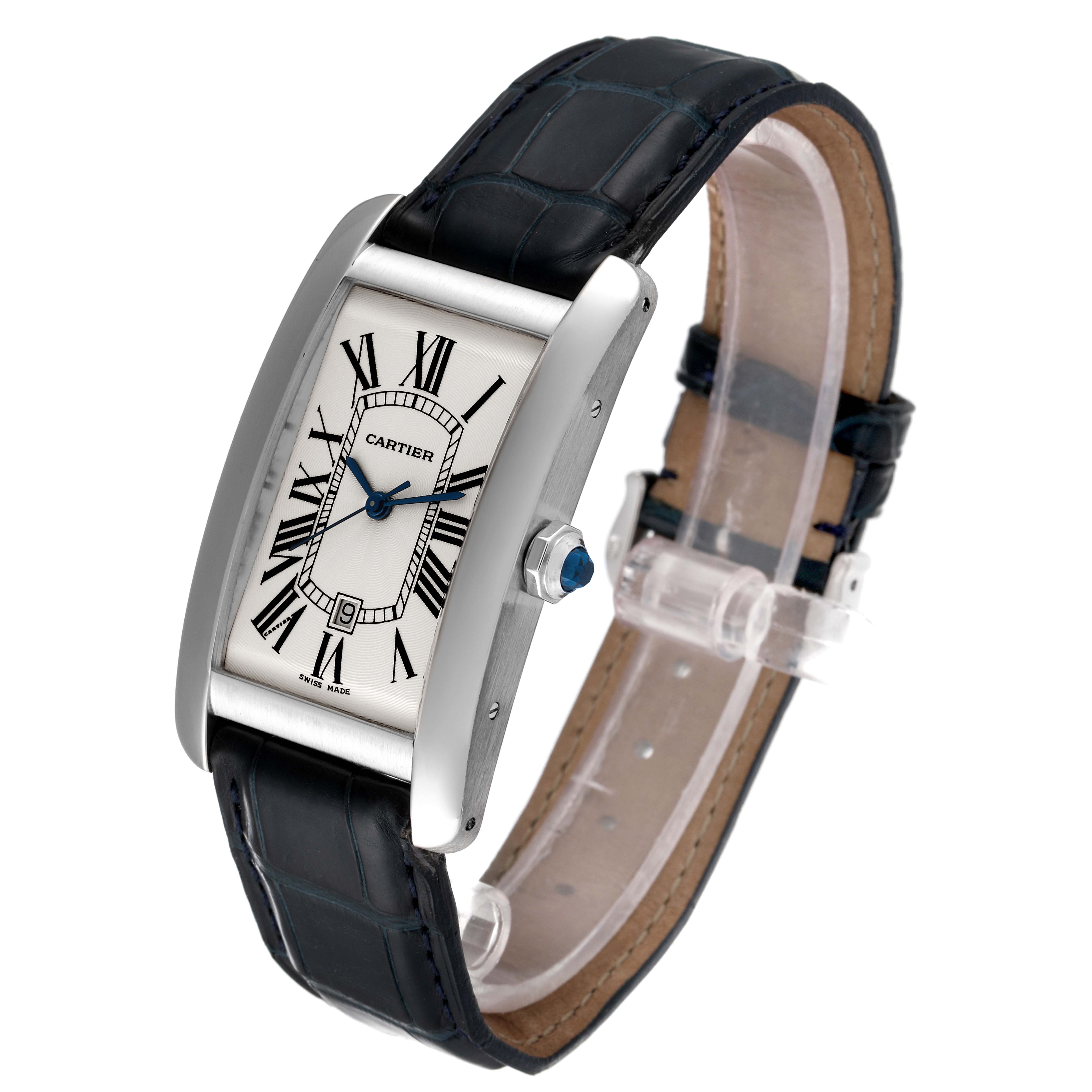 This is a Cartier Tank Americaine W2603256 Men's White Gold Silver Dial W2603256 Men's White Gold Silver Dial watch shown at an angle, displaying the face, strap, case, and crown with the blue gem detail.