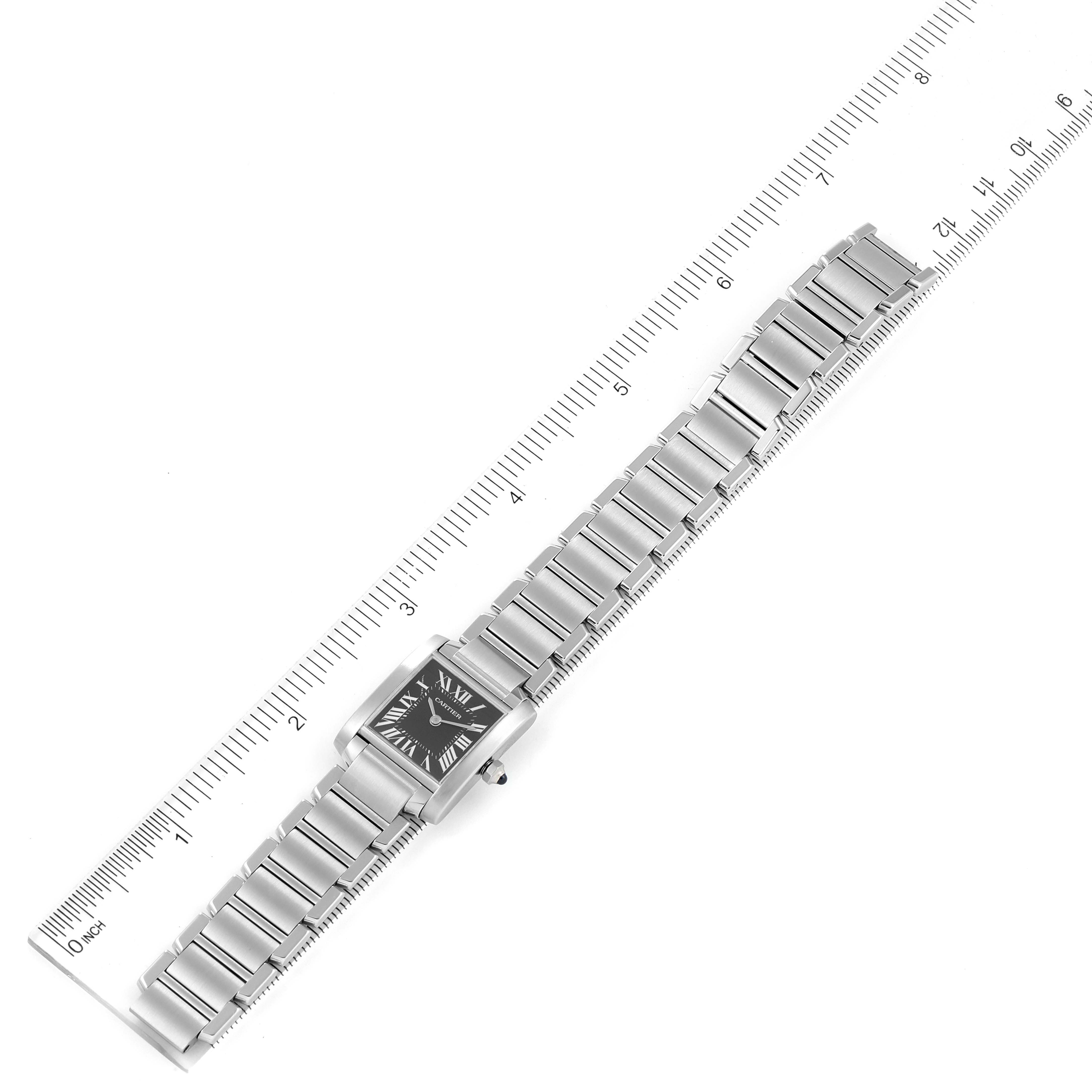 This is an overhead view of the Cartier Tank Francaise W51026Q3 Women's Stainless Steel Black Dial W51026Q3 Women's Stainless Steel Black Dial watch, showing its stainless steel band and face with a ruler for scale.