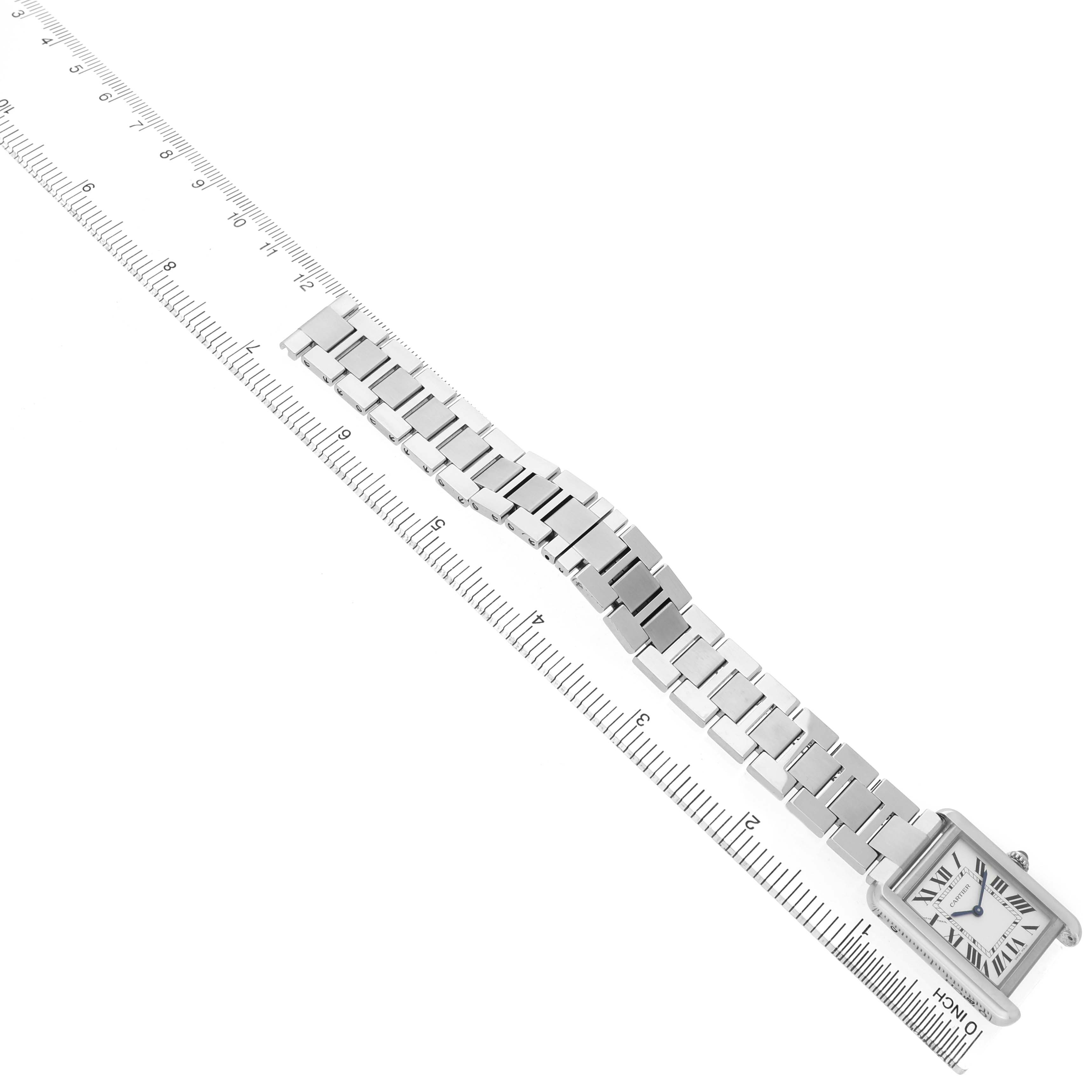 The Cartier Tank Solo W5200013 Women's Stainless Steel Silver Dial watch is shown from a top-down angle, displaying its rectangular face and metal bracelet, alongside a ruler for scale.