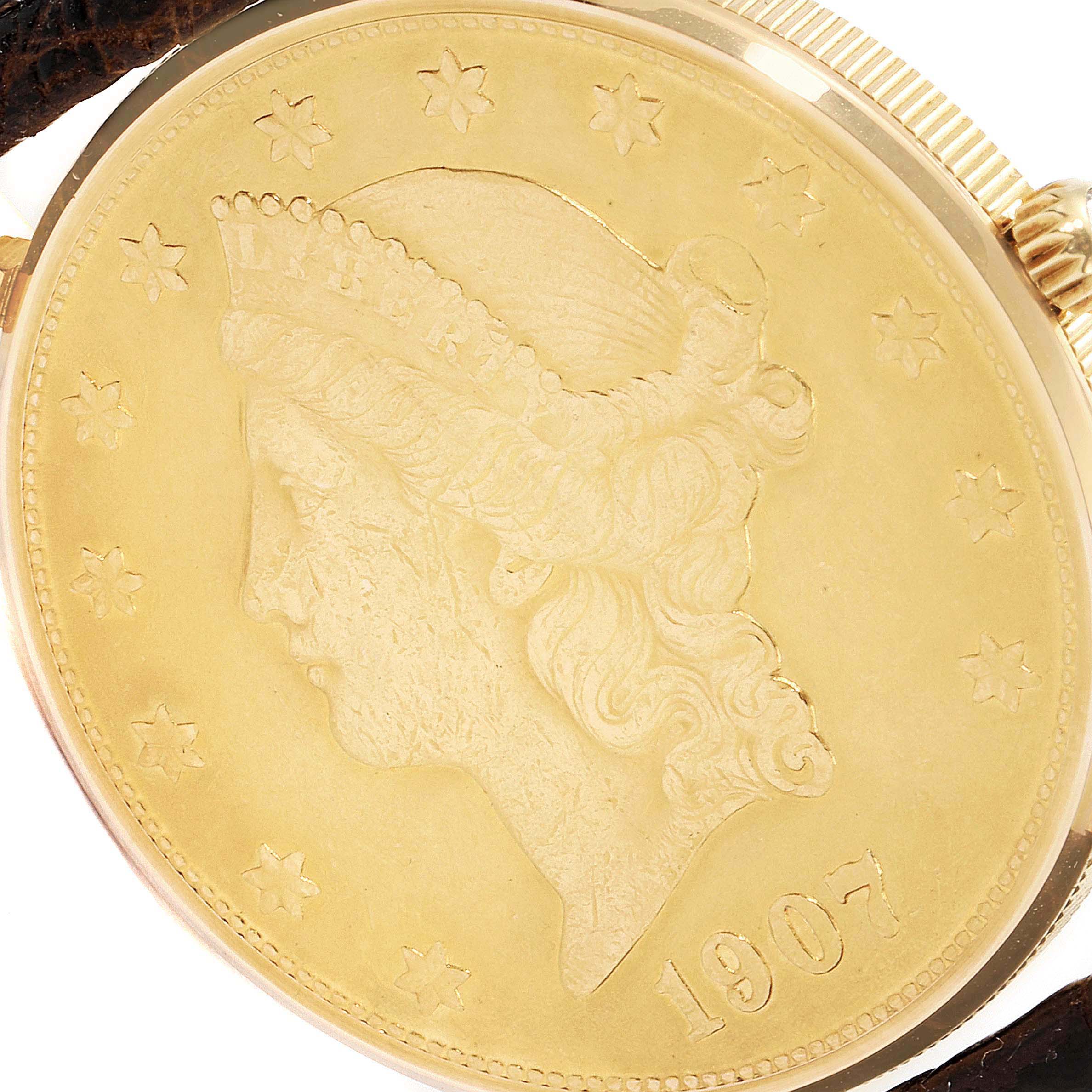 This image shows a close-up of the face and crown of the Corum Coin Watch  Men's Yellow Gold Black Dial  Men's Yellow Gold Black Dial model, featuring a coin design from 1907.