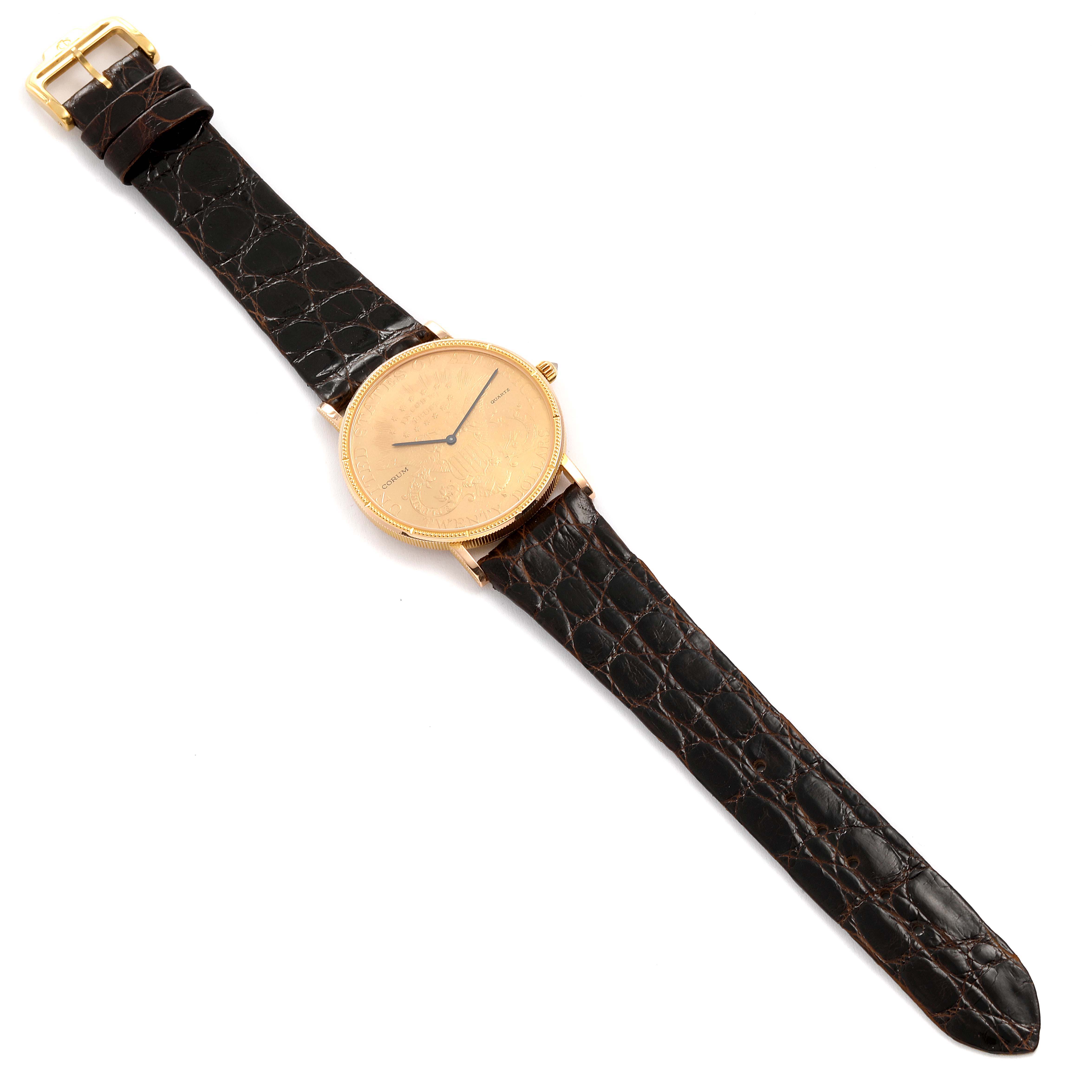 This image shows the Corum Coin Watch  Men's Yellow Gold Black Dial  Men's Yellow Gold Black Dial model from a top-down angle, displaying the entire watch face, strap, and buckle.