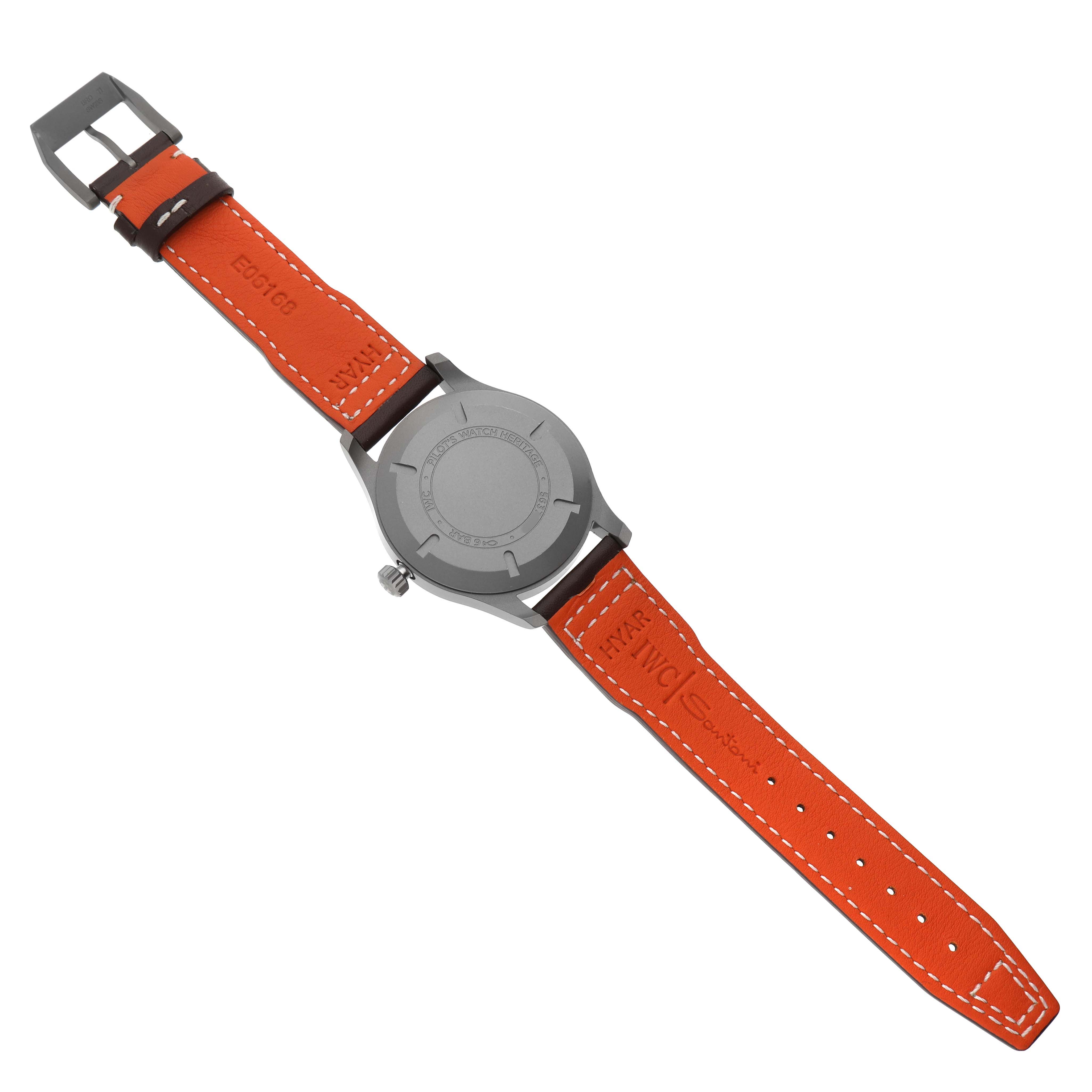 The IWC Pilot IW327006 Men's Titanium Black Dial model watch is shown from the back, displaying the case back and orange leather strap with buckle.