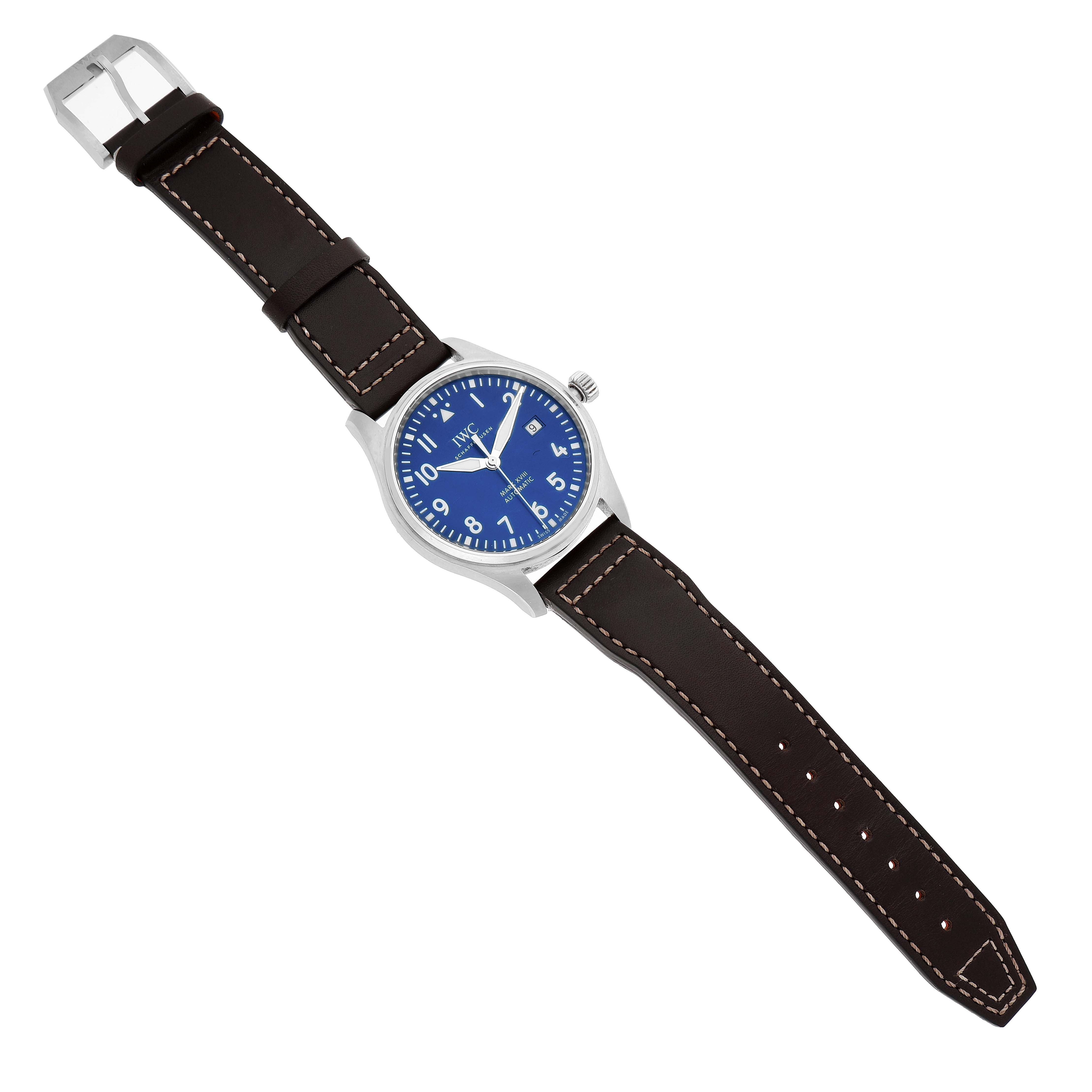 The IWC Pilot IW327010 Men's Stainless Steel Blue Dial watch is shown from an angled top view, displaying the blue face, bezel, crown, and brown leather strap.