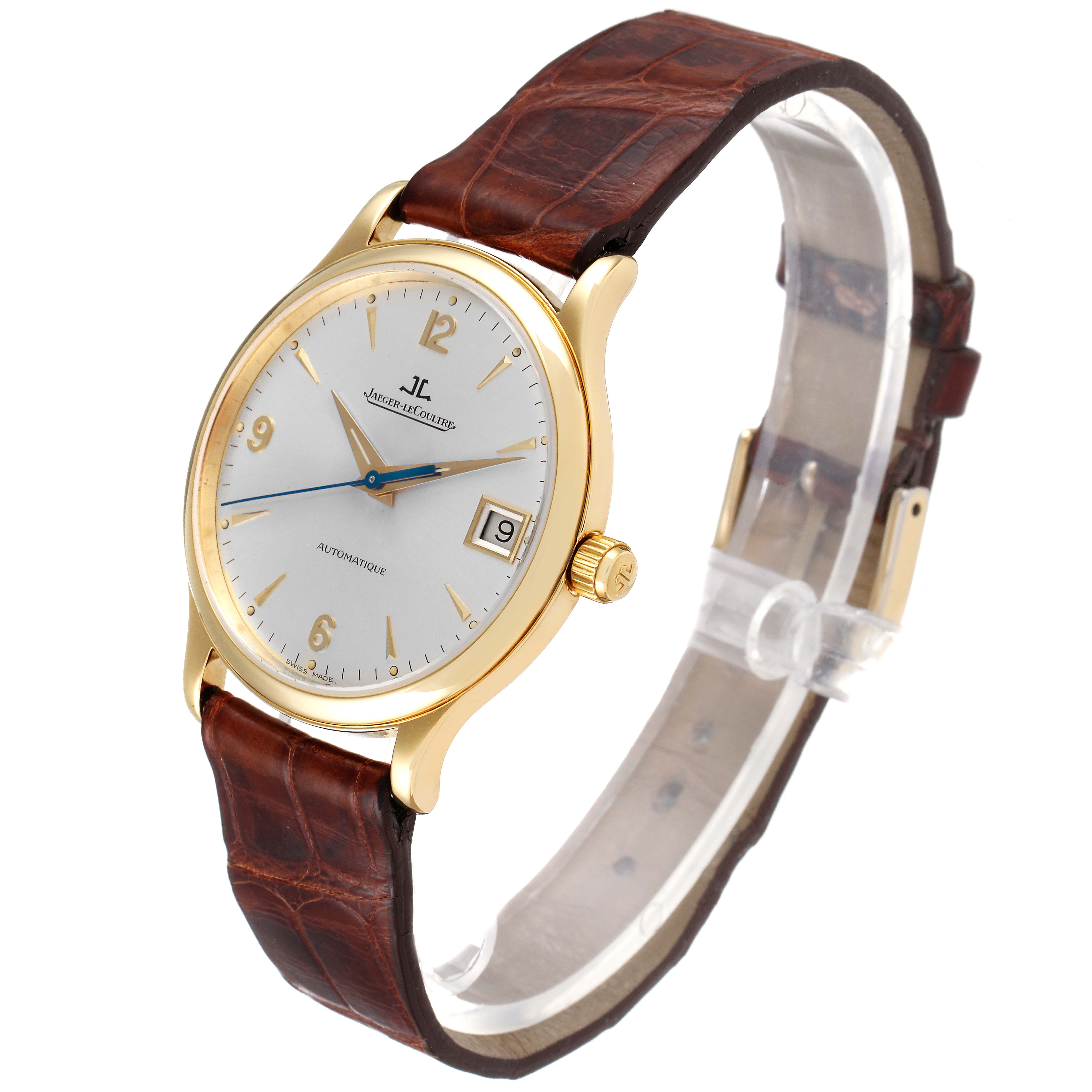 The Jaeger LeCoultre Master 145.1.89 Men's Yellow Gold Silver Dial 145.1.89 Men's Yellow Gold Silver Dial watch is shown at a slight angle, displaying the face, gold case, brown strap, and date indicator.